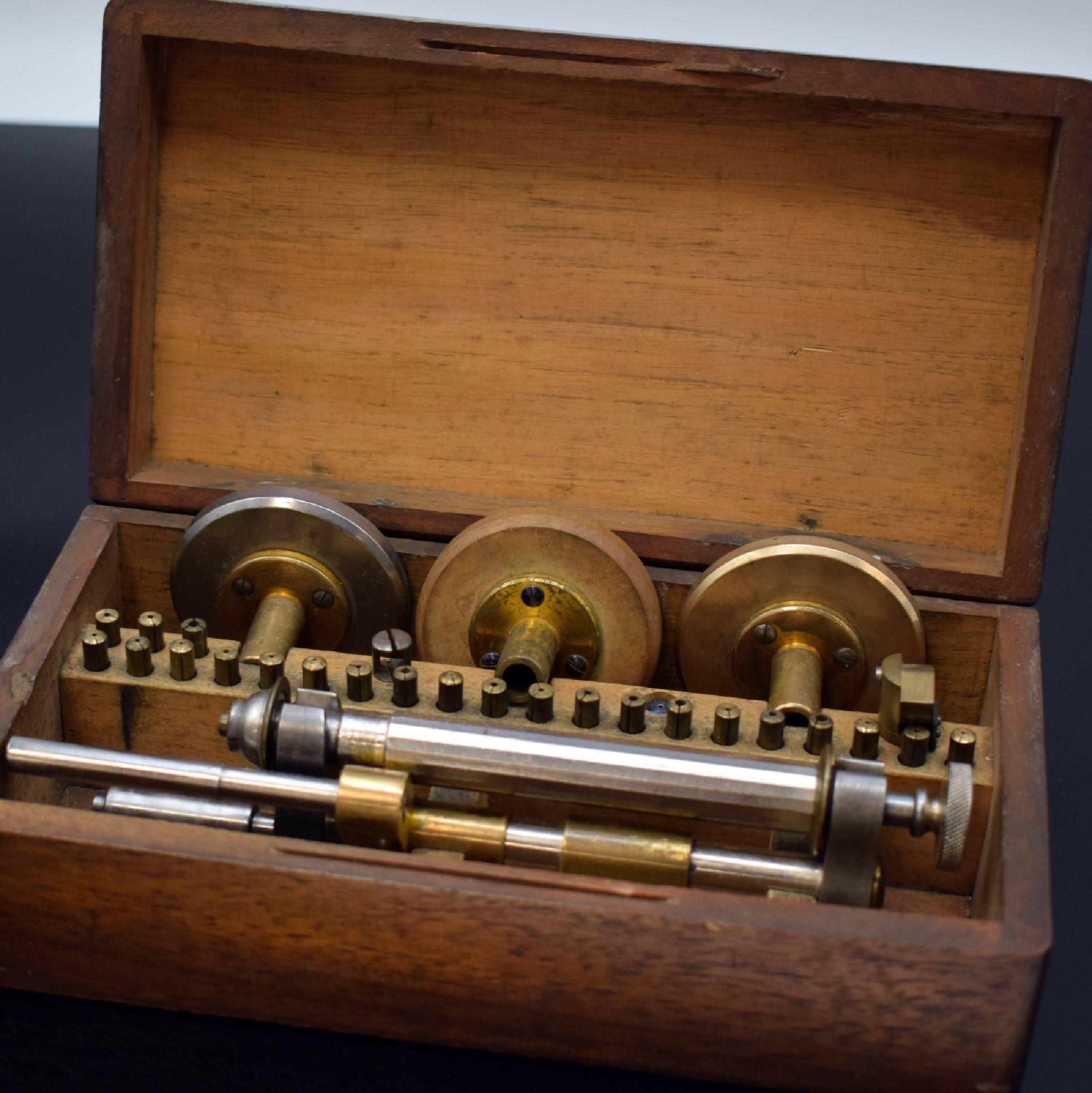Detail a: Uhrmacher-Werkzeug 3 Teile, 1) Schraubenkopf-Poliermaschine im original Holzkasten, div. Spannvorrichtungen und Polierscheiben anbei, 2) Bügelfräse ...