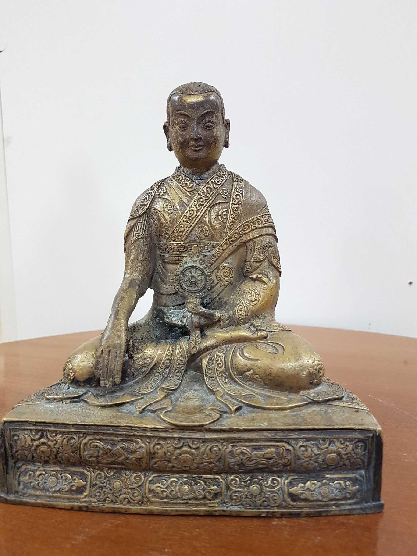 Detail b: Bronzeskulptur eines Lama, 19. Jh., Tibet, sehr schön verzierter Thron, Lotus bzw. Vajrasitz, reich verziertes Gewand, in der linken Hand das Rad ...