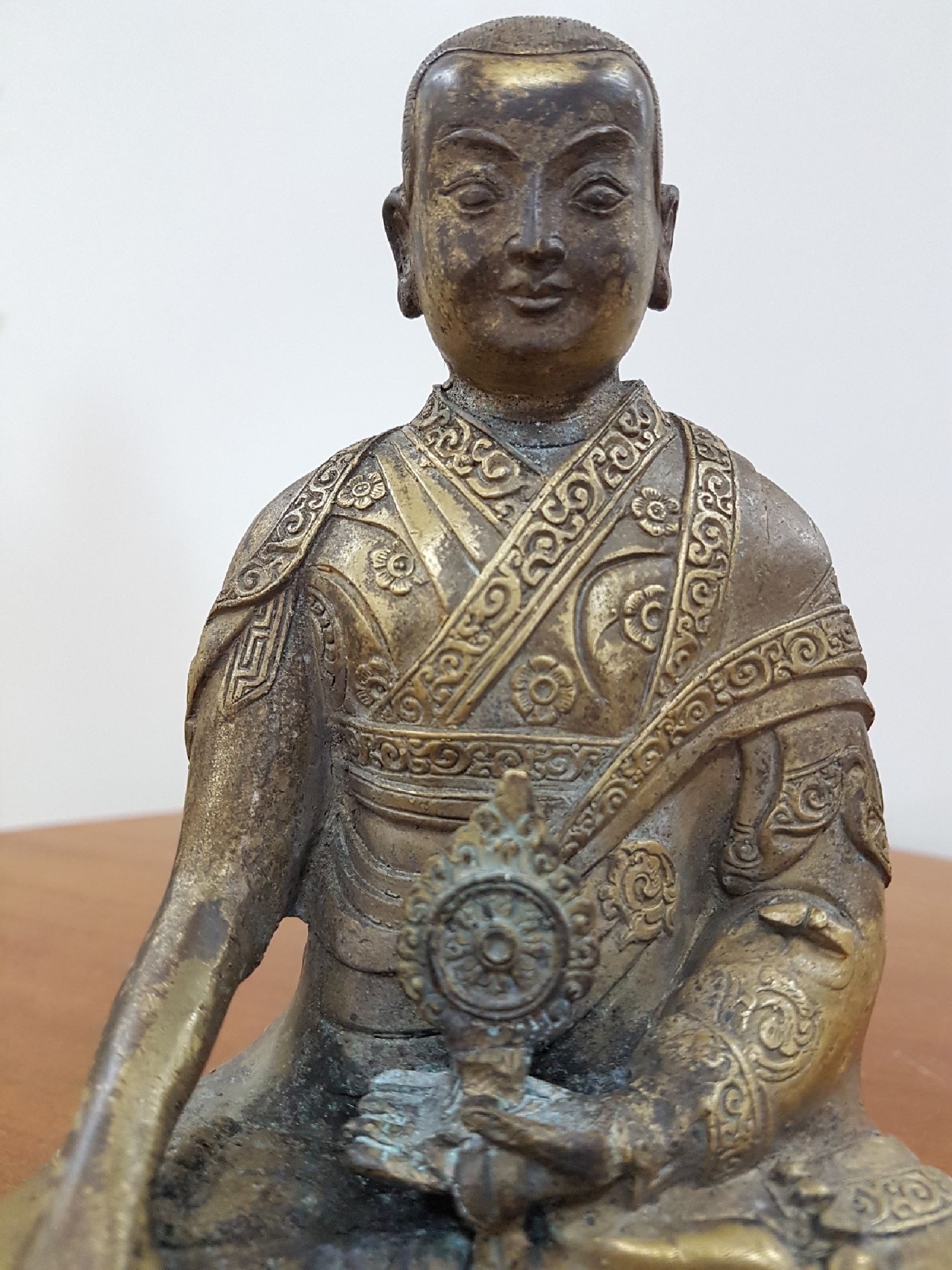 Detail f: Bronzeskulptur eines Lama, 19. Jh., Tibet, sehr schön verzierter Thron, Lotus bzw. Vajrasitz, reich verziertes Gewand, in der linken Hand das Rad ...