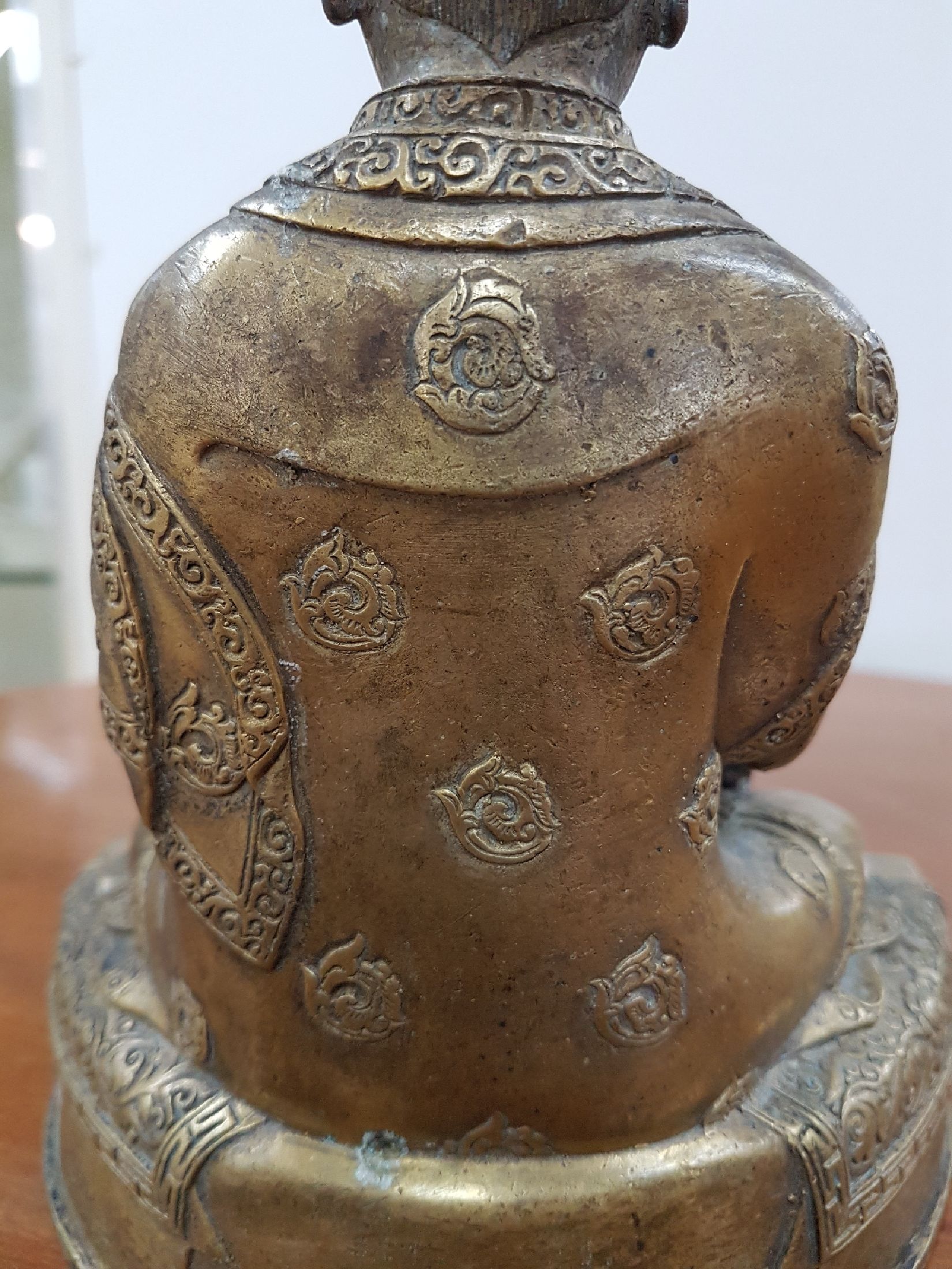 Detail j: Bronzeskulptur eines Lama, 19. Jh., Tibet, sehr schön verzierter Thron, Lotus bzw. Vajrasitz, reich verziertes Gewand, in der linken Hand das Rad ...