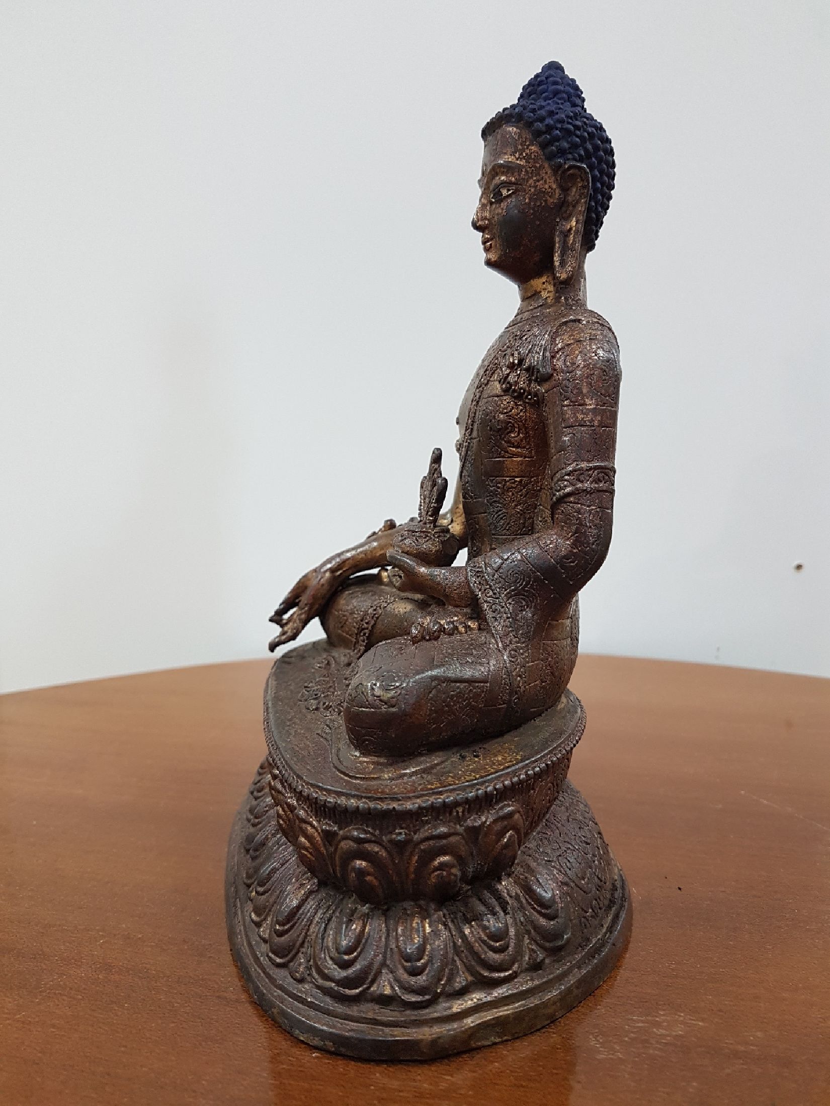 Detail c: Medizin-Buddha, Tibet, um 1900, Bronze, Reste von Vergoldung, verziertes Gewand, ca. 22 x 16 x 11 cm