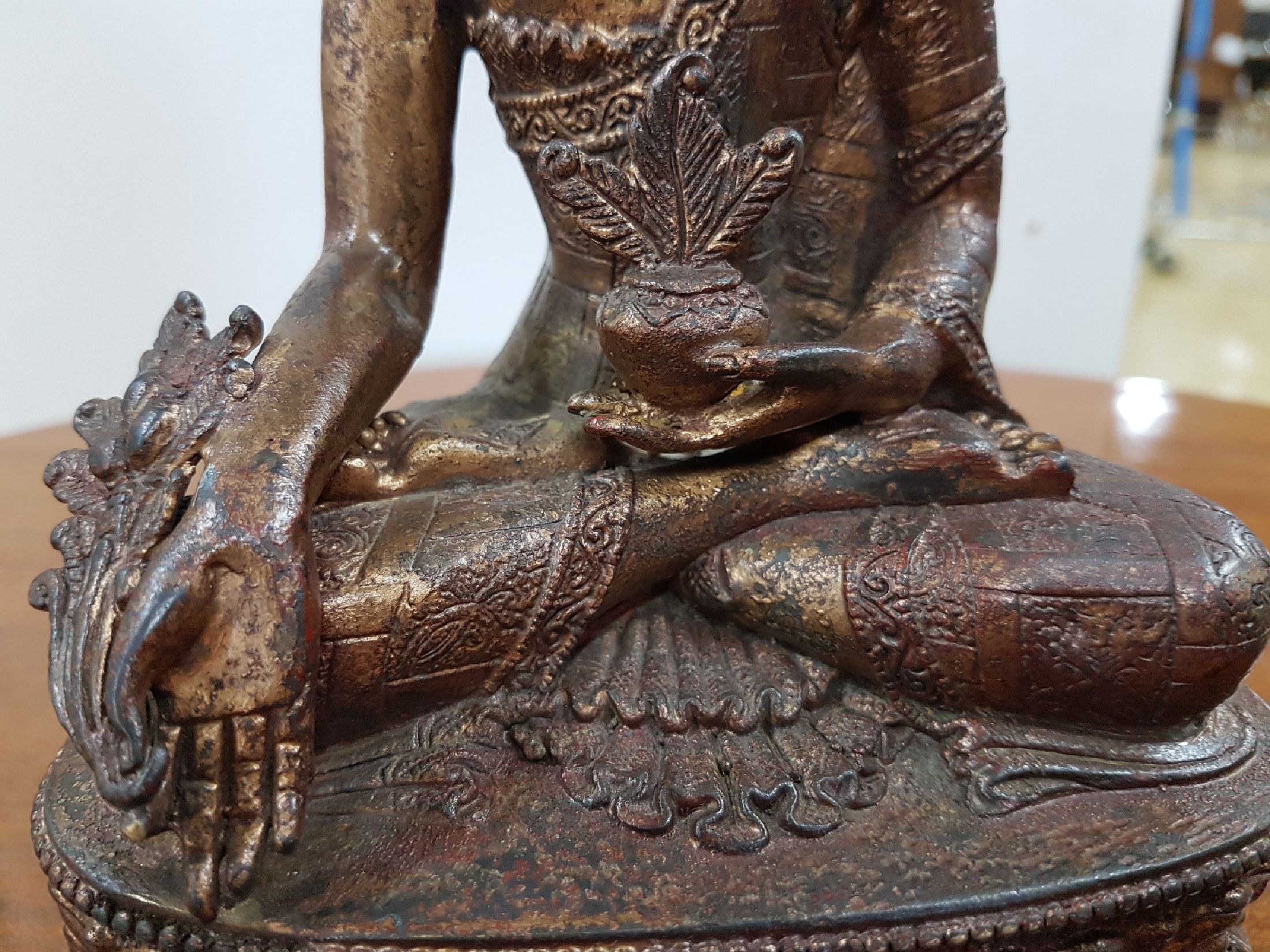 Detail f: Medizin-Buddha, Tibet, um 1900, Bronze, Reste von Vergoldung, verziertes Gewand, ca. 22 x 16 x 11 cm