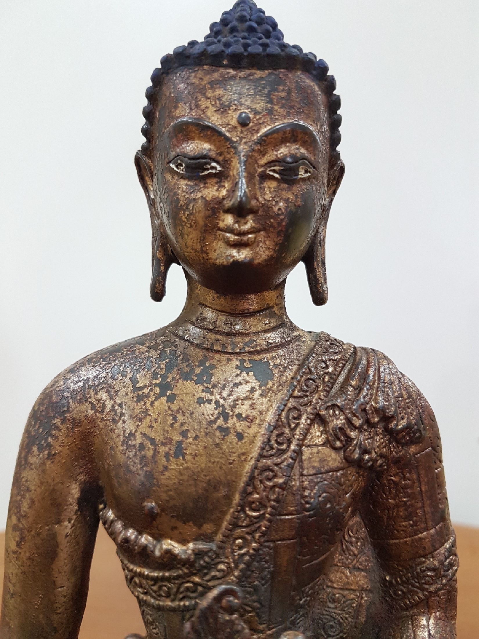 Detail g: Medizin-Buddha, Tibet, um 1900, Bronze, Reste von Vergoldung, verziertes Gewand, ca. 22 x 16 x 11 cm