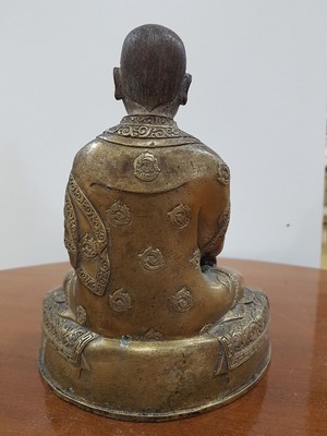 26638989d - Bronze sculpture of a lama, 19th century, Tibet, very beautifully decorated throne, lotus or vajra seat, richly decorated robe, holding the wheel of teaching in the left hand, approx. 19.5 x 16.5 x 11 cm