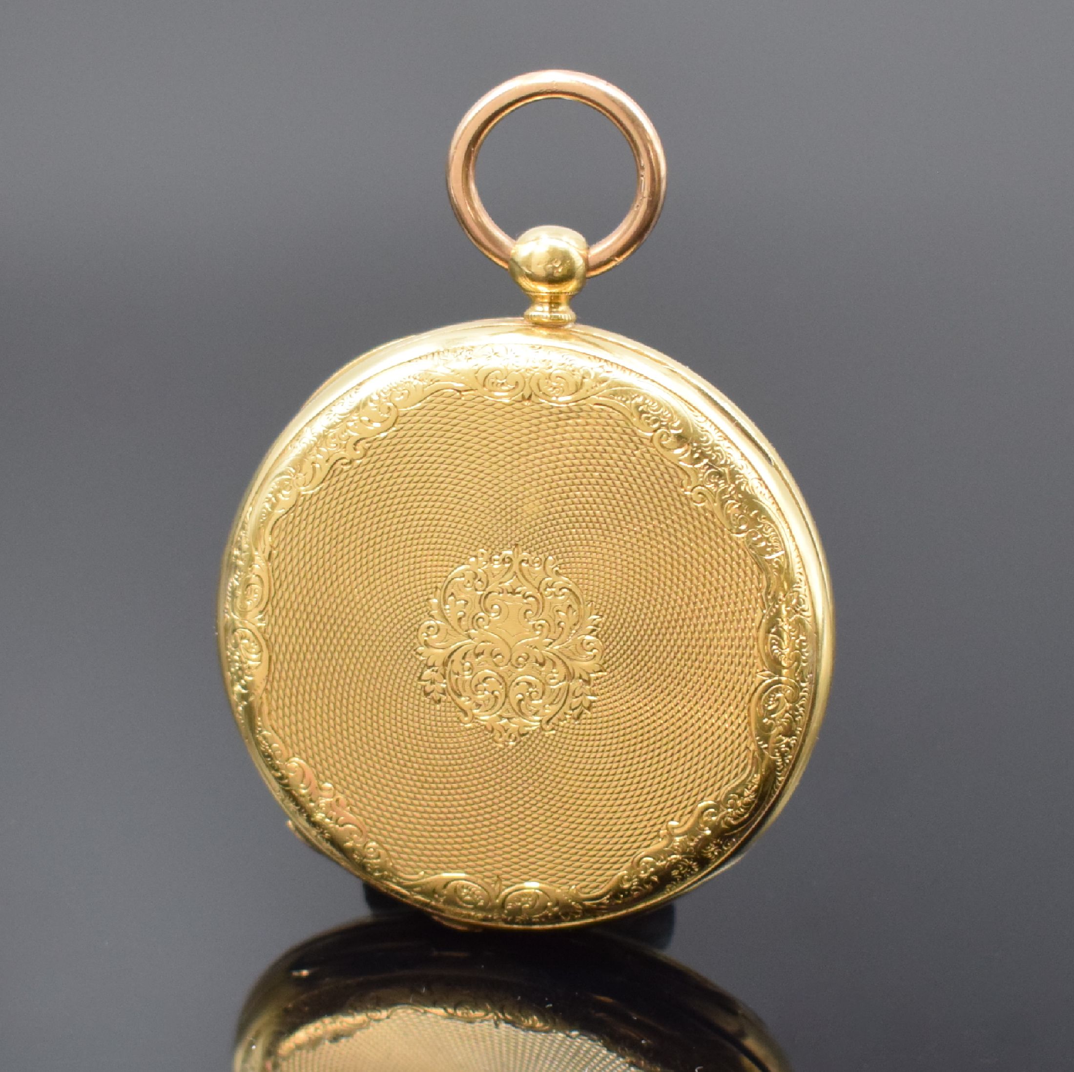 Detail a: Offene Taschenuhr in GG 750/000, Schweiz um 1870, Rückseite aufwend. grav. u. guill., Metallcuvette, Emailzifferbl. m. röm. Zahlen, gebl. Zeiger, ...