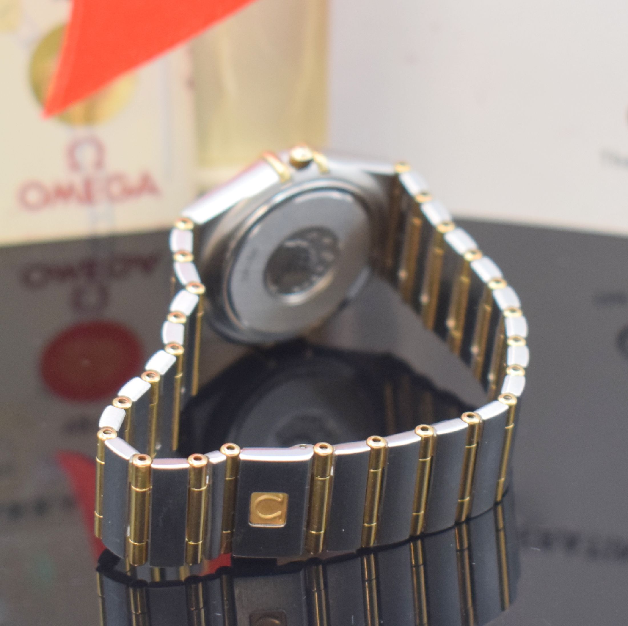 Detail b: OMEGA Damenarmbanduhr Serie Constellation Referenz 1287.70.00, quarz, Edelstahl/Gold kombiniert inkl. Gliederband m. Faltschl., Boden m. Darst. ...