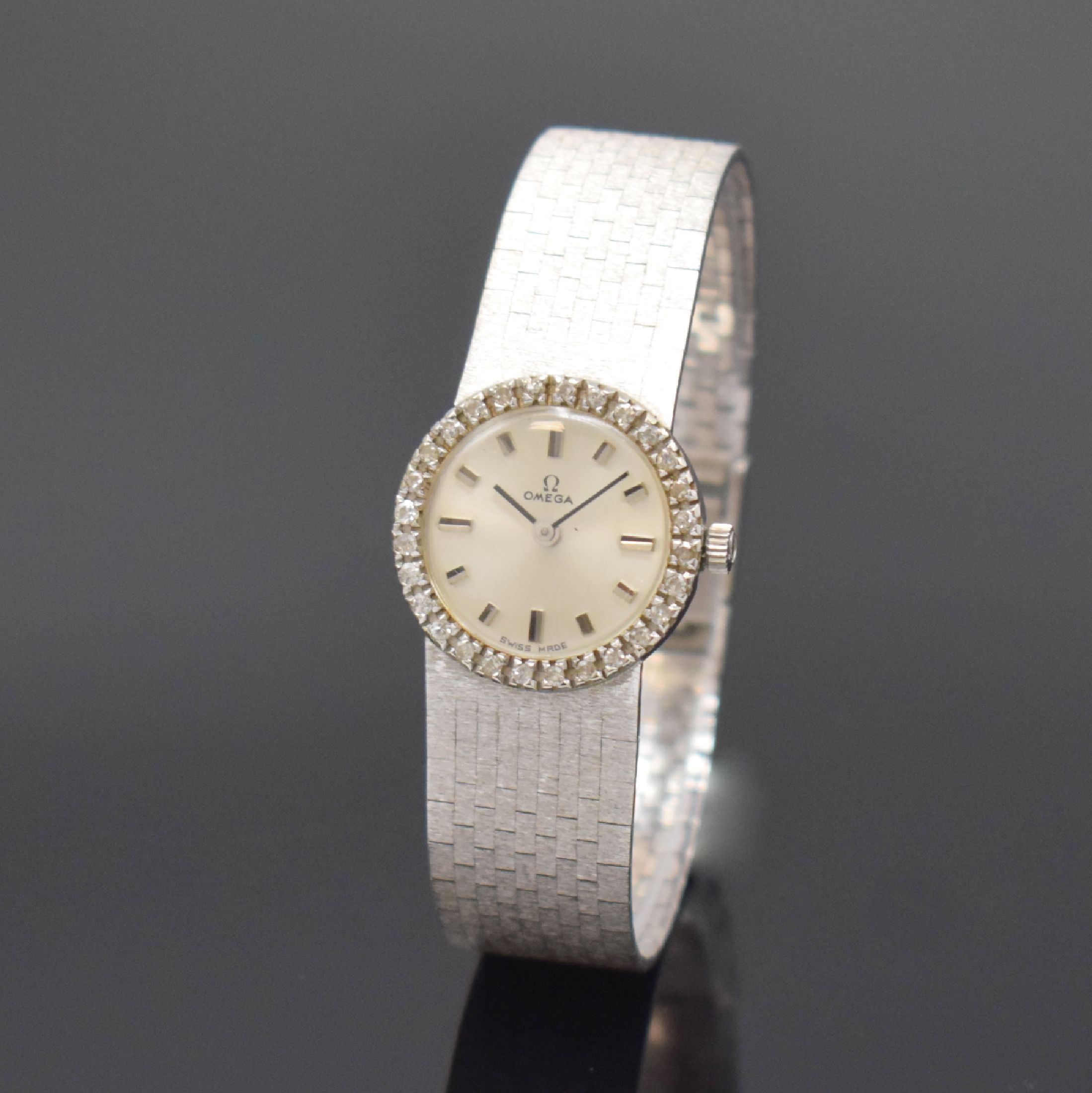 OMEGA diamantbesetzte Damenarmbanduhr in WG 750/000, Schweiz/Deutschland um 1965, Handaufzug, neutrales Geh., anges. fein mattiertes Band, silb. ...