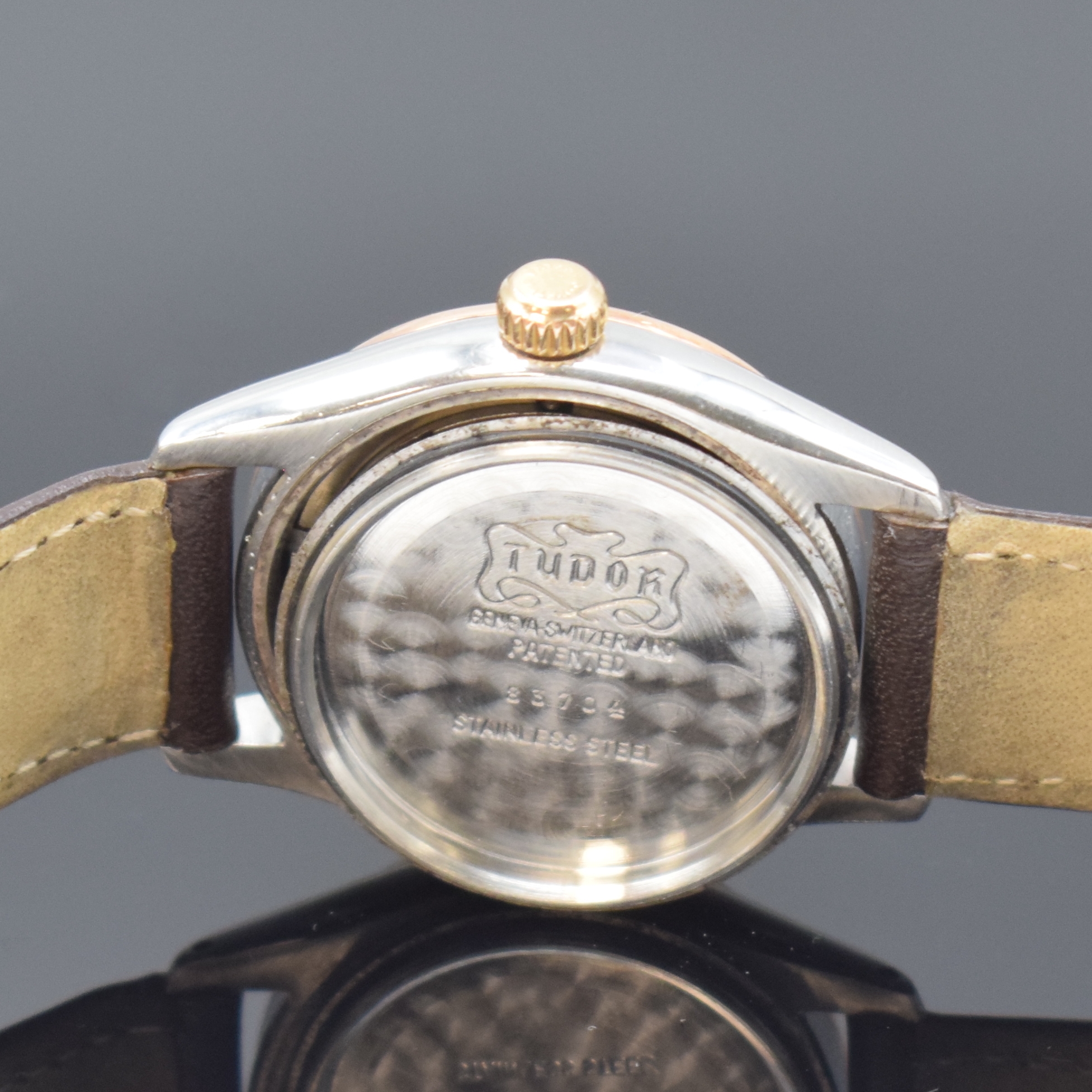 Detail e: TUDOR Oyster Armbanduhr in Stahl/Gold Referenz 7803, Schweiz um 1955, Handaufzug, Boden u. Krone verschr., cremefarb. Zifferbl. rest., gold. ...