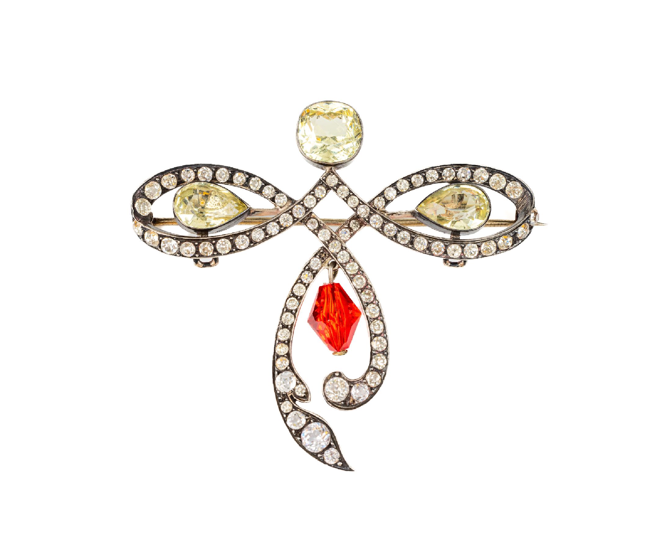 Brosche, Frankreich um 1910, stil. Schleifenform in asymm. Aufbau, Silber geprüft, farbloser und zart-gelber Strassbesatz, bewegl. roter ...