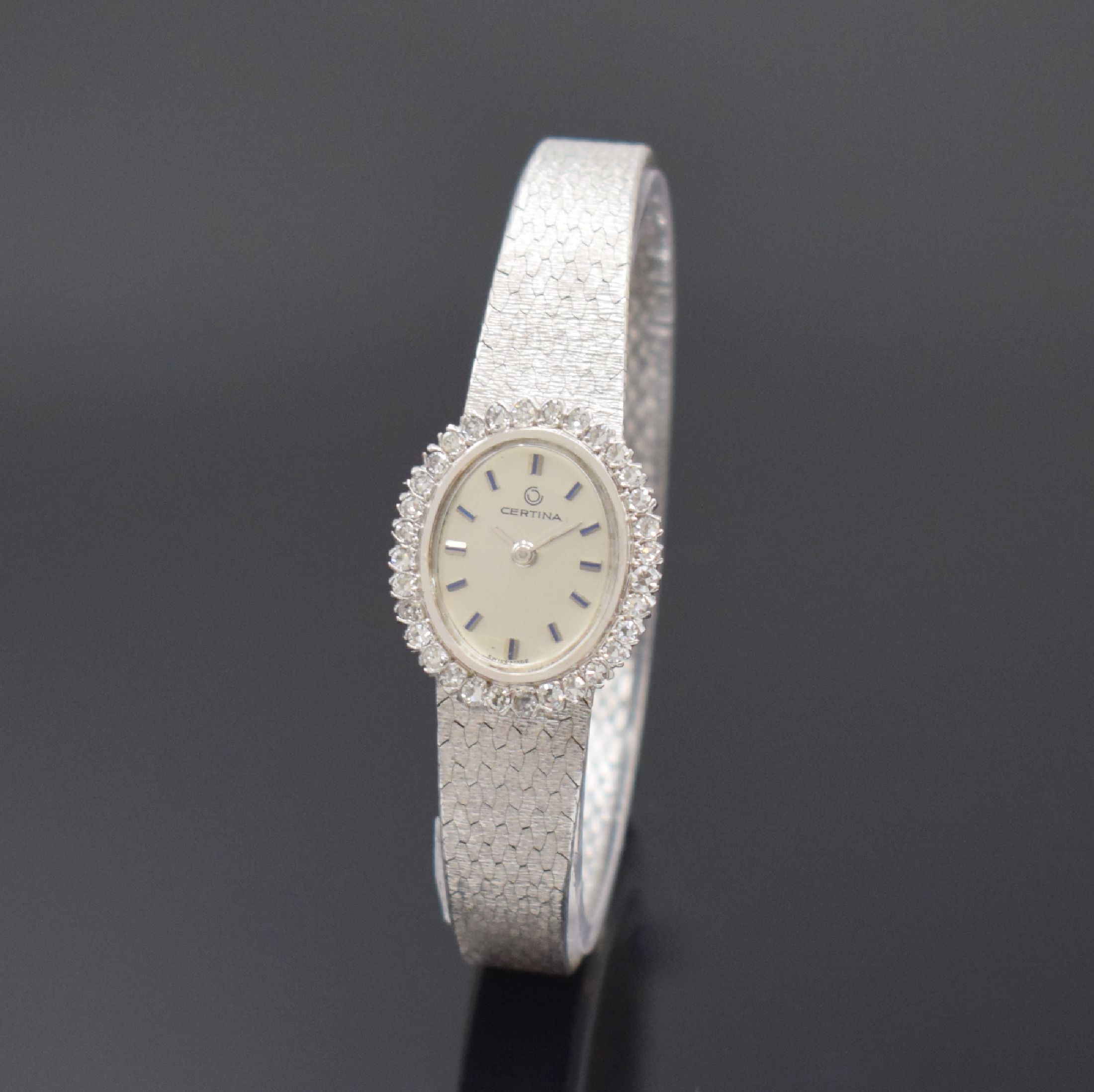 CERTINA diamantbesetzte Damenarmbanduhr in WG 750/000, Schweiz um 1970, Handaufzug, gedr. Geh., integr. orig. Band, silb. Zifferbl., aufges. silb. ...