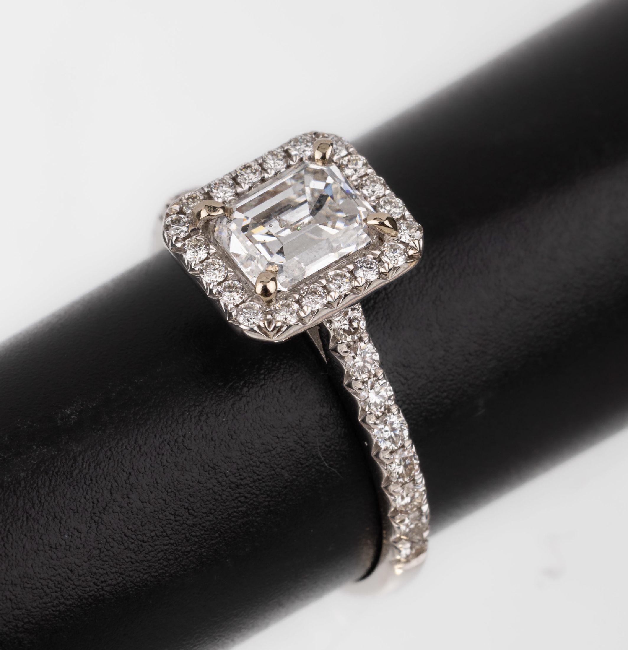 18 kt Gold Diamant-Ring, WG 750/000, Diamant im Emerald Cut ca. 1.02 ct Weiß/p1, umgeben und seitl. mit Brillanten zus. ca. 0.45 ct Weiß/vvs-vs, ...