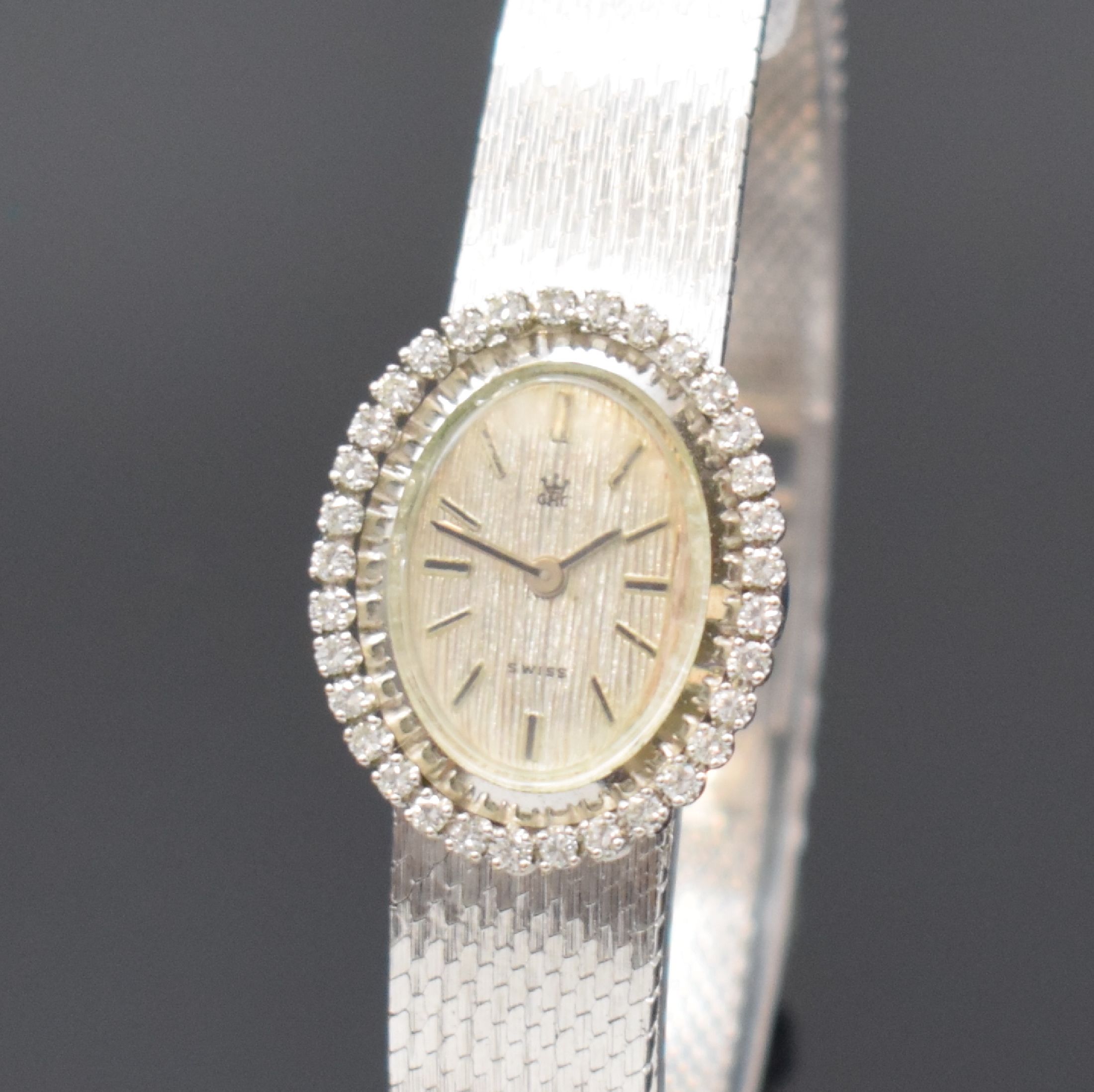 Detail a: GHC Damenarmbanduhr in WG 585/000, Schweiz um 1970, Handaufzug, 2-teil. Geh., Boden aufgedr., Milanaiseband, Lünette m. Diamanten bes., silb. ...