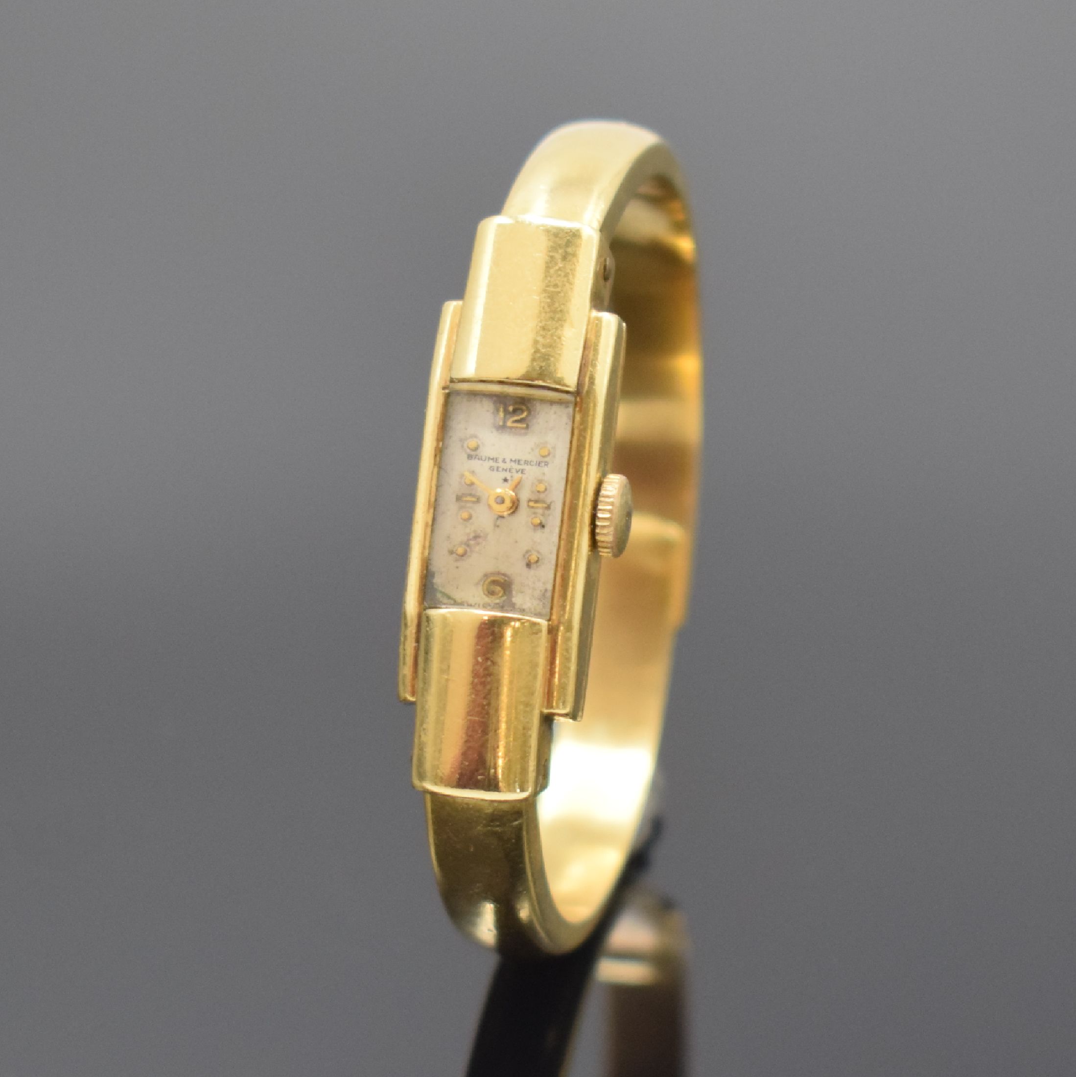 BAUME & MERCIER Spangenuhr in GG 750/000, Schweiz um 1940, Handaufzug, Boden aufgedr., silb. Zifferbl. altersbed. pat./fl., gold. Std.-Ind. u. ...