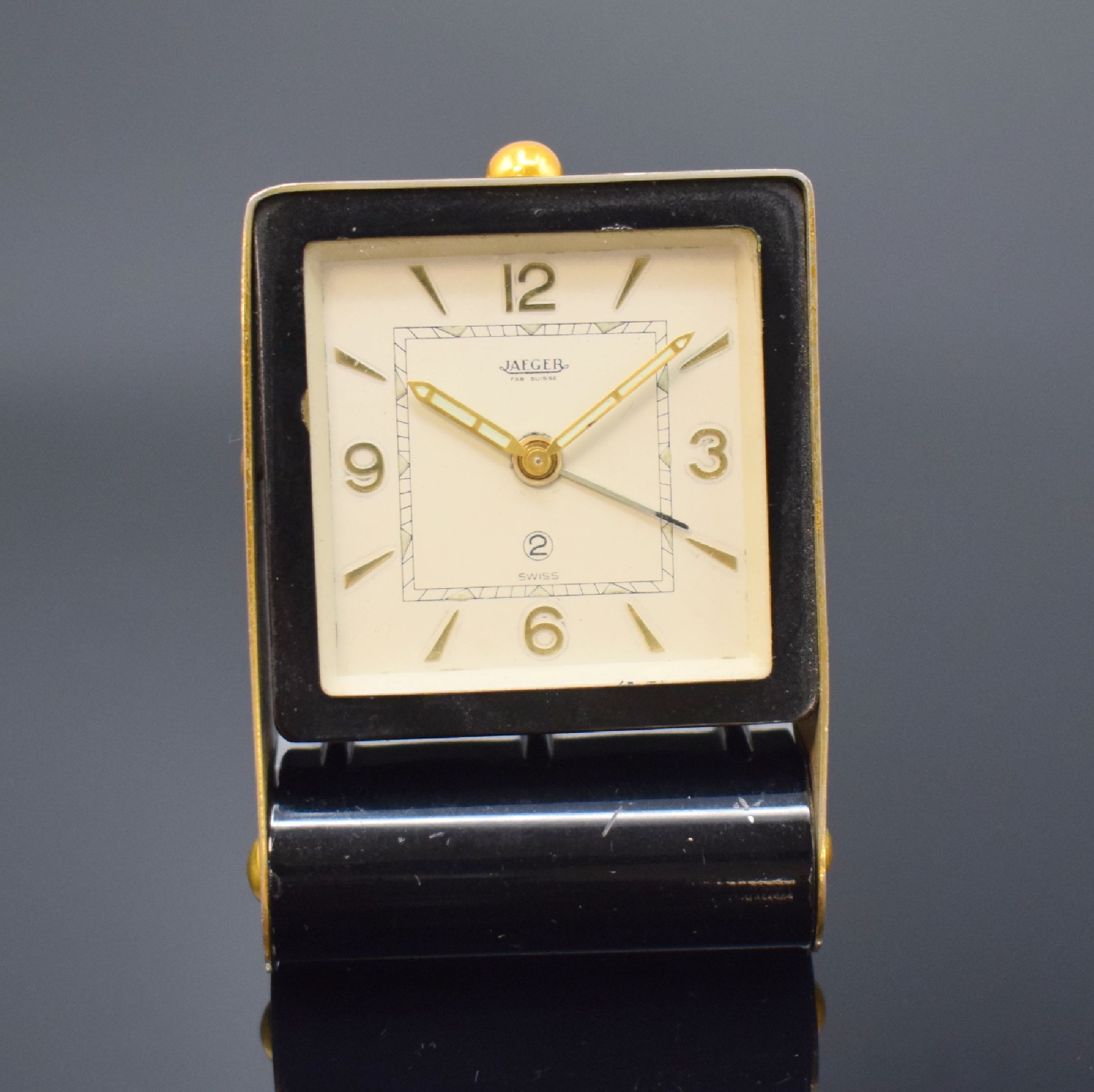 JAEGER Reisewecker, Schweiz um 1950, Schlüsselaufzug, aufklappbares Metallgeh., teils schwarz lack., teils verg., silb. Zifferbl., gold. Indizes u. ...