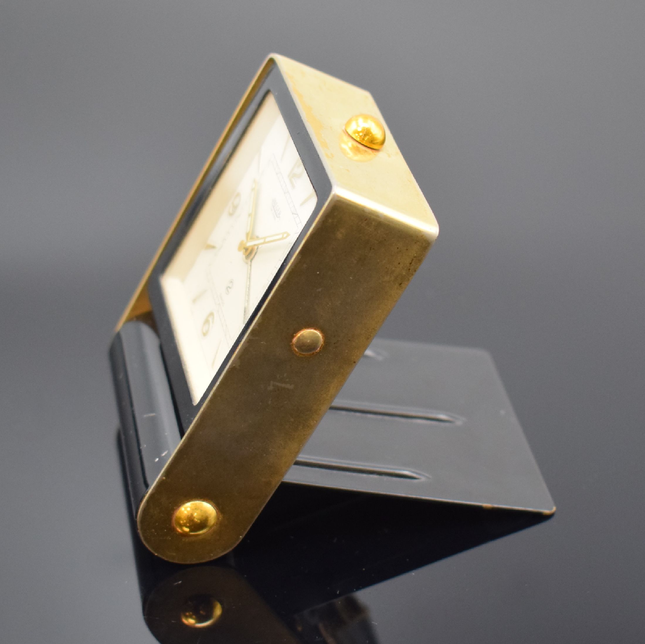Detail d: JAEGER Reisewecker, Schweiz um 1950, Schlüsselaufzug, aufklappbares Metallgeh., teils schwarz lack., teils verg., silb. Zifferbl., gold. Indizes u. ...