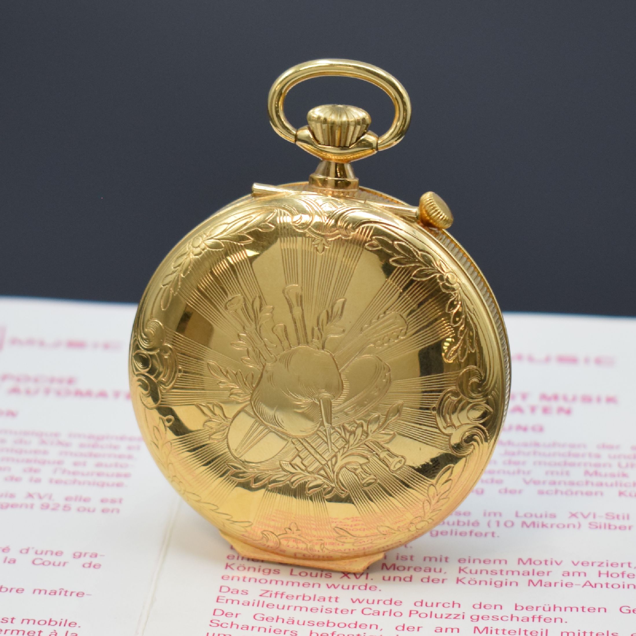 Detail a: REUGE Taschenuhr mit Wecker-Spieluhr und Figurenautomat, Schweiz um 1990, verg. Geh., Rückdeckel m. grav. Musikinstrumenten, weißes Zifferbl. b. ...