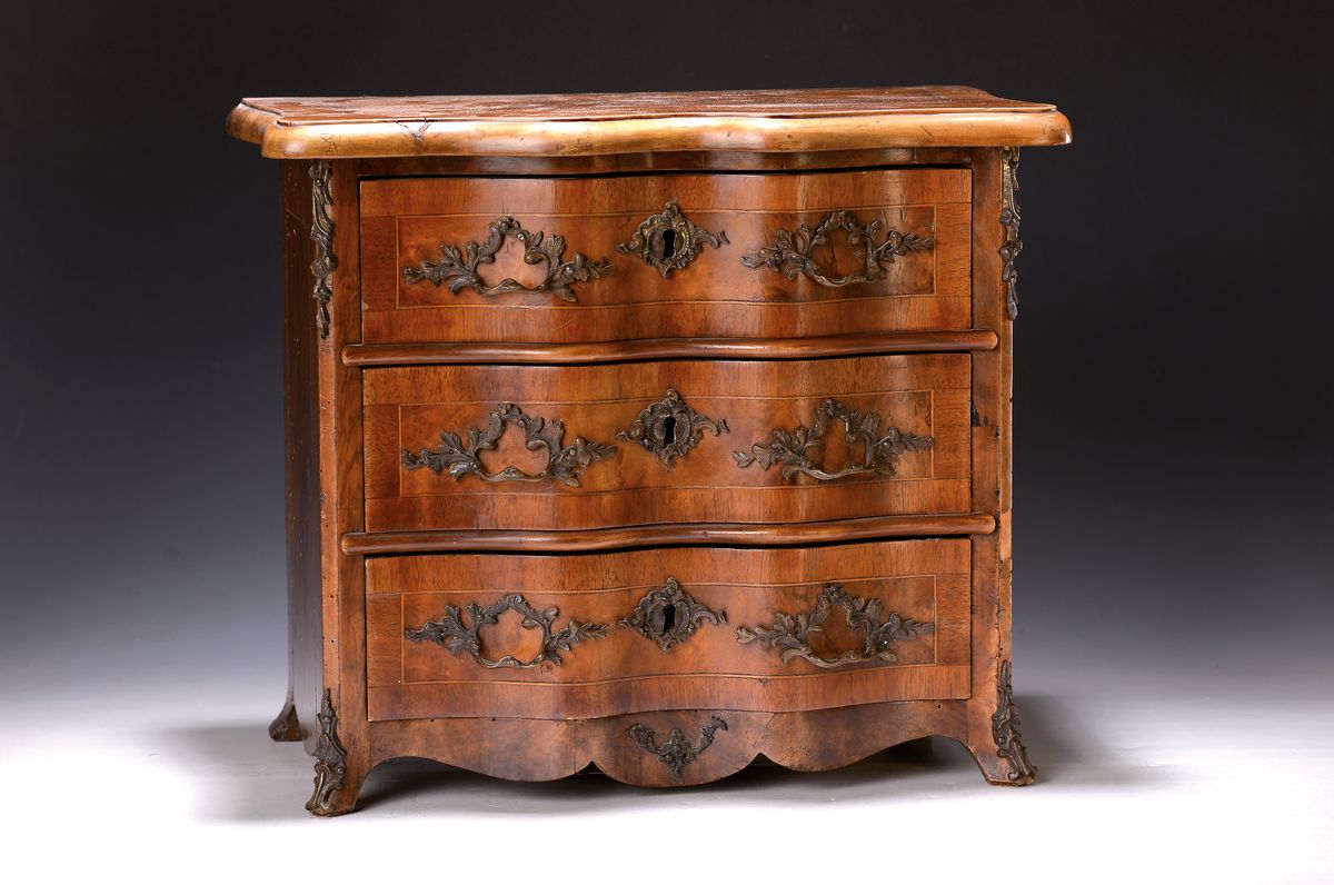 Miniaturkommode im Barockstil, 19.Jh., Nußbaumfurnier, 4-schübig, geschweifte Front, Bronzebeschläge, ohne Schlösser u. Schlüssel, ehemaliger ...