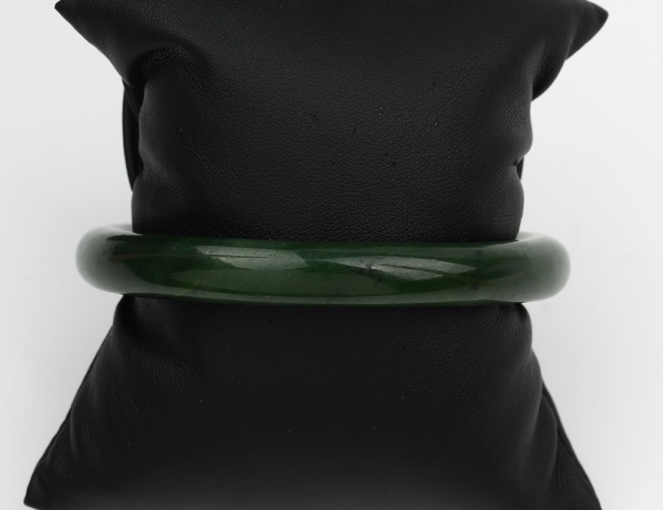 Detail b: Jade-Konvolut, best. aus: 1 Armreif, D. ca.6.5 cm, und 1 Collier aus Jadekugeln, D. ca. 8.1 mm, L. ca. 93.5 cm, Federringschließe Metall verg.