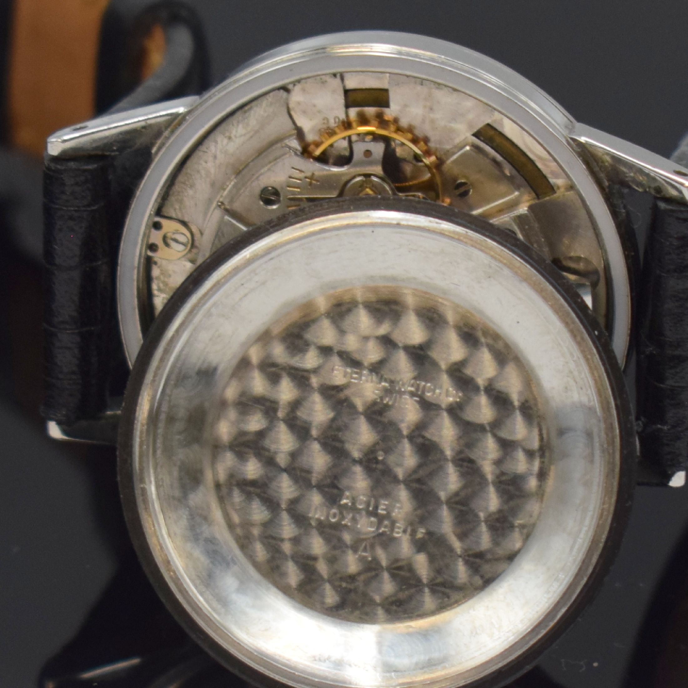 Detail g: OMEGA / ETERNA 2 Armbanduhren in Stahl, Schweiz um 1935 / 1955, Handaufzug / Automatik, 1.) rechteck. OMEGA, gedr. Geh., schwarz. Zifferbl. rest., ...