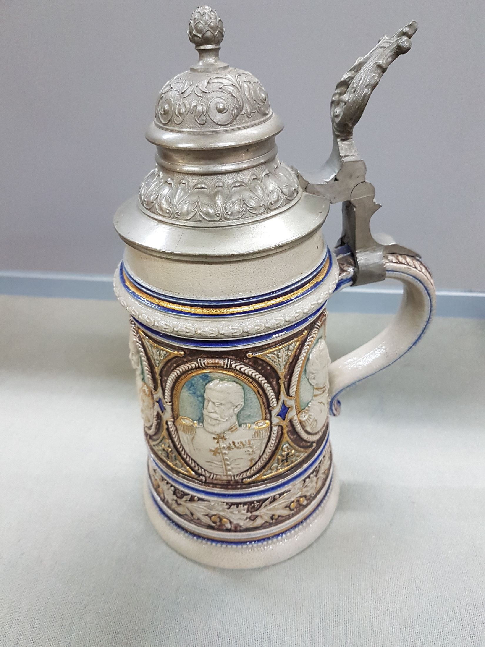 Detail c: Bierkrug, deutsch, um 1900, Steinzeug, reich reliefiert mit den 5 Porträts von Kaiser Wilhelm I, Kaiser Friedrich III, Kaiser Wilhelm II., König ...