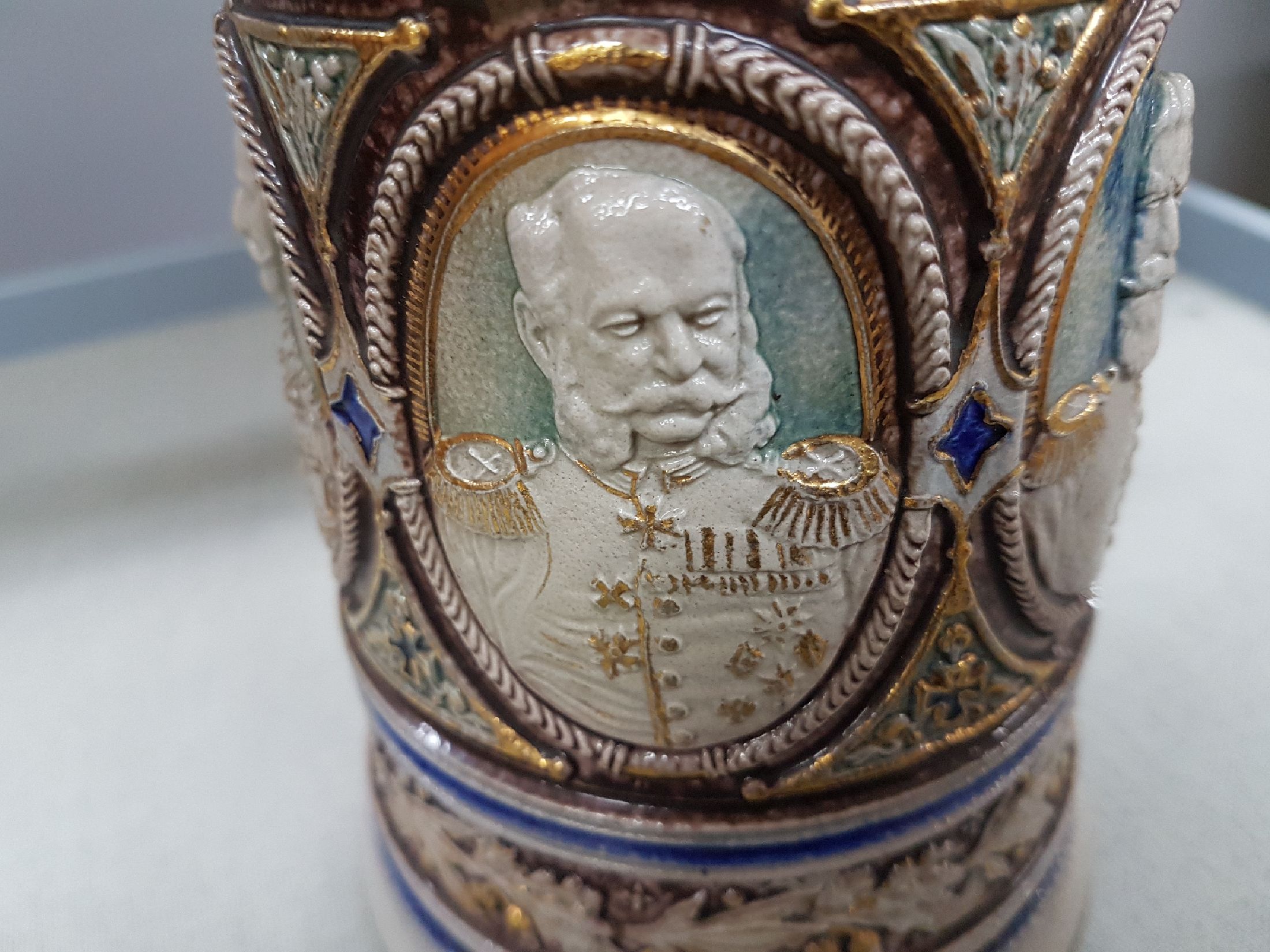 Detail g: Bierkrug, deutsch, um 1900, Steinzeug, reich reliefiert mit den 5 Porträts von Kaiser Wilhelm I, Kaiser Friedrich III, Kaiser Wilhelm II., König ...