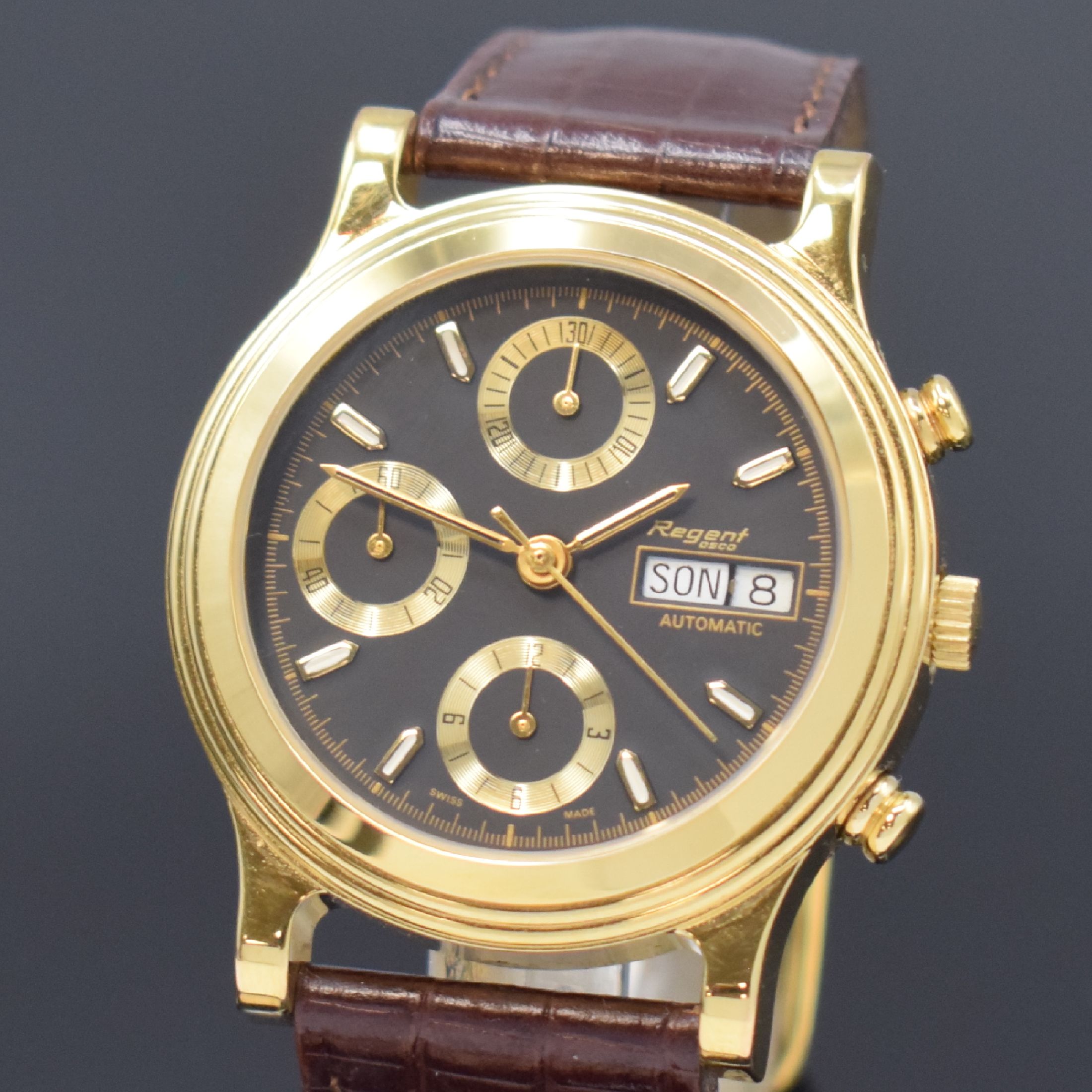Detail a: REGENT Armbandchronograph, Automatik, Schweiz um 1990, verg. Geh., Edelstahlboden aufgedr., schwarzes Zifferbl. m. gold. Indizes, Tag und Datum bei ...