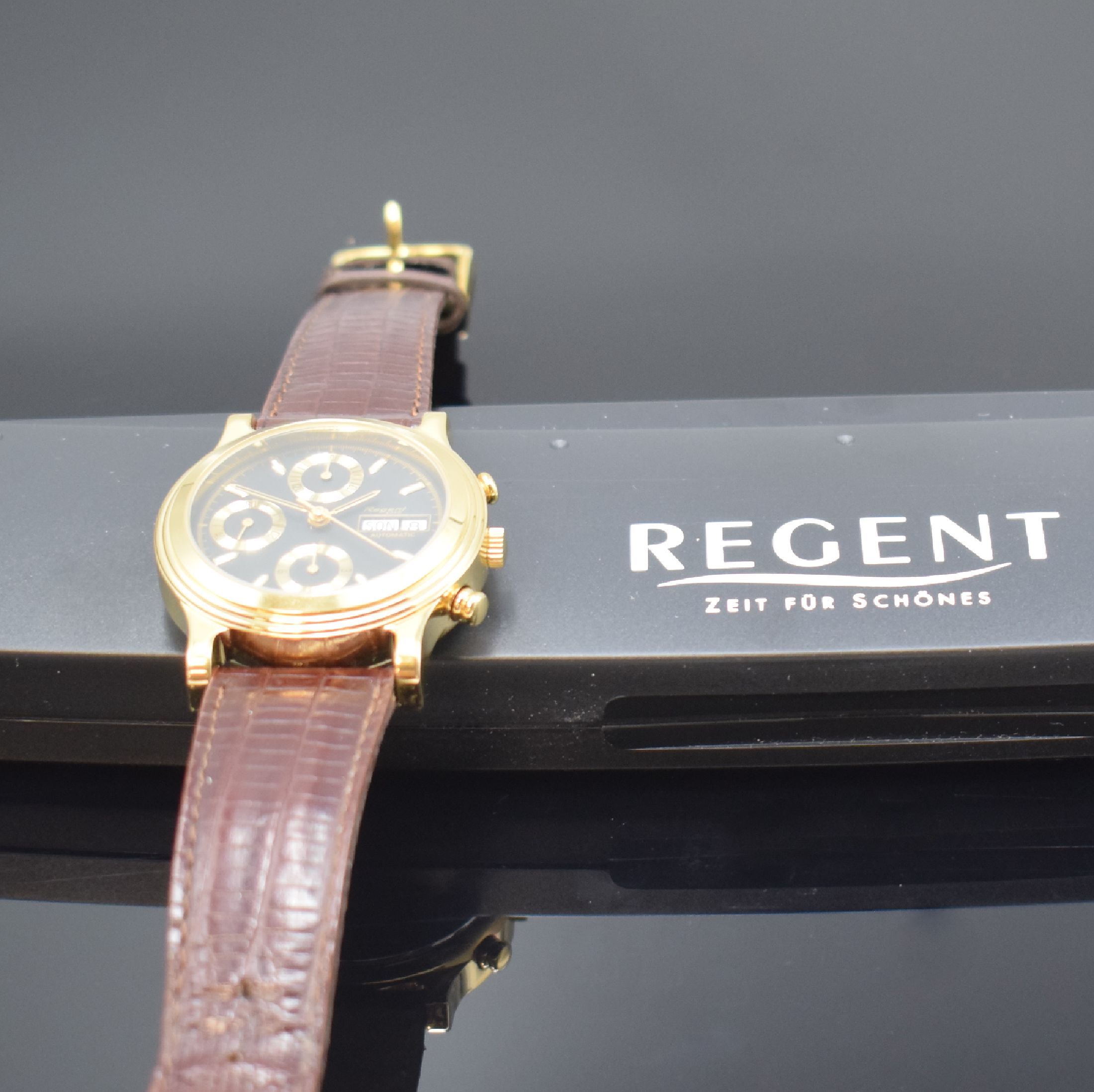 Detail d: REGENT Armbandchronograph, Automatik, Schweiz um 1990, verg. Geh., Edelstahlboden aufgedr., schwarzes Zifferbl. m. gold. Indizes, Tag und Datum bei ...