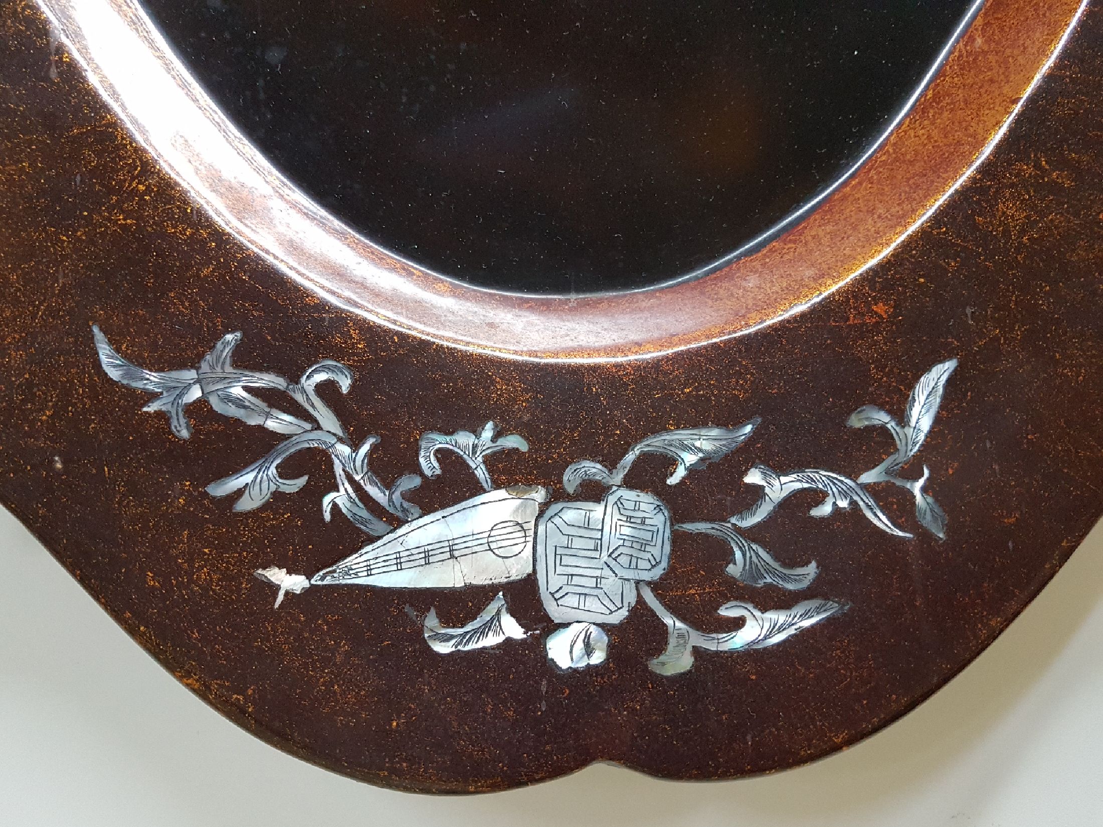 Detail b: Große Lacktablett, Japan, Mitte 20. Jh., mittig mit Perlmuttdarstellung, Geisha und zwei Personen, Fahne mit Blumen und Allegorien auf die Musik ...