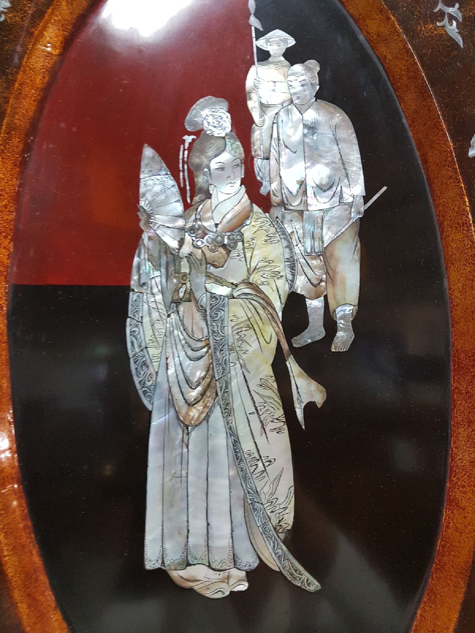 Detail c: Große Lacktablett, Japan, Mitte 20. Jh., mittig mit Perlmuttdarstellung, Geisha und zwei Personen, Fahne mit Blumen und Allegorien auf die Musik ...