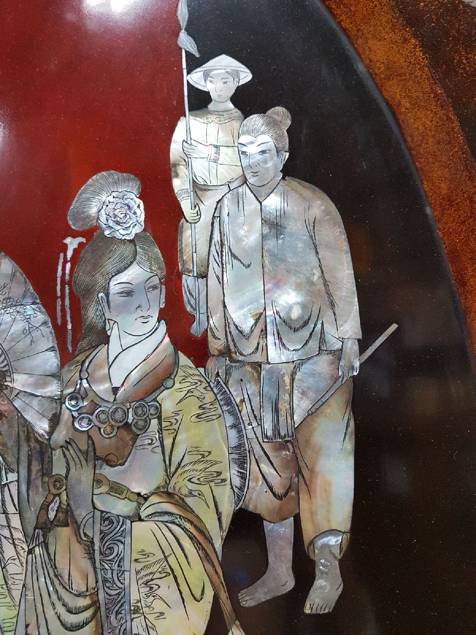Detail e: Große Lacktablett, Japan, Mitte 20. Jh., mittig mit Perlmuttdarstellung, Geisha und zwei Personen, Fahne mit Blumen und Allegorien auf die Musik ...