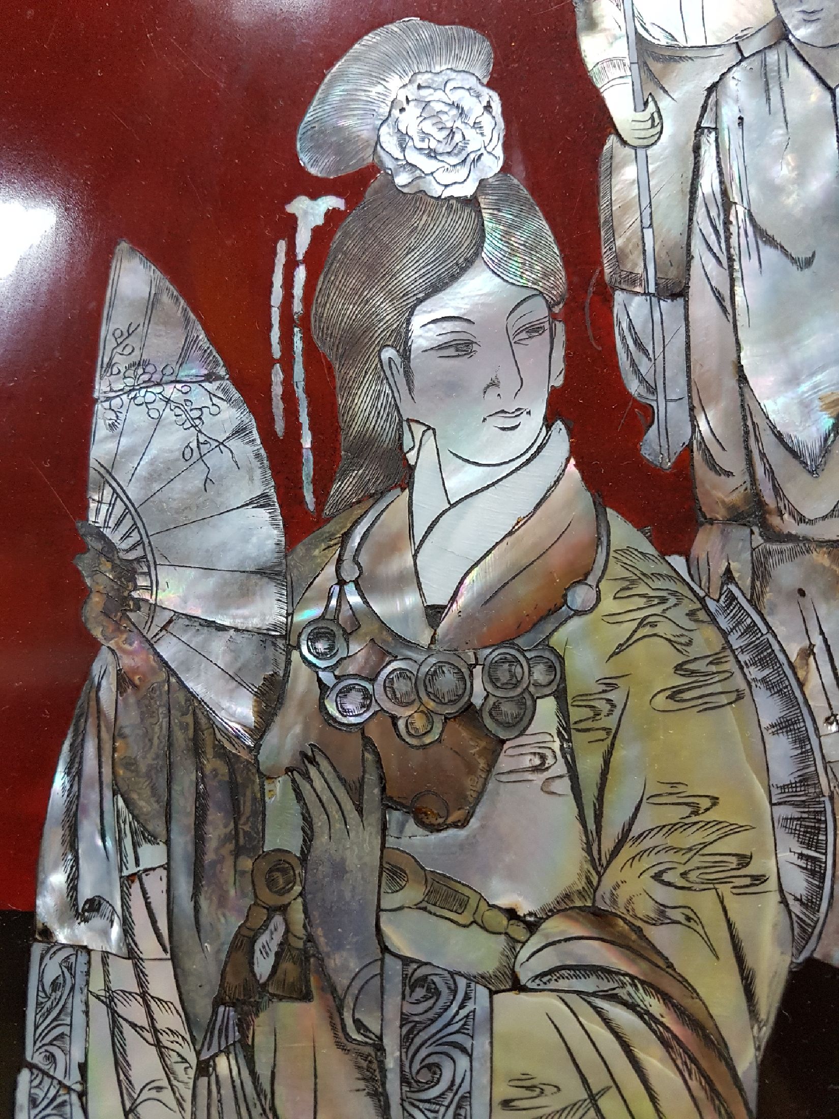 Detail f: Große Lacktablett, Japan, Mitte 20. Jh., mittig mit Perlmuttdarstellung, Geisha und zwei Personen, Fahne mit Blumen und Allegorien auf die Musik ...