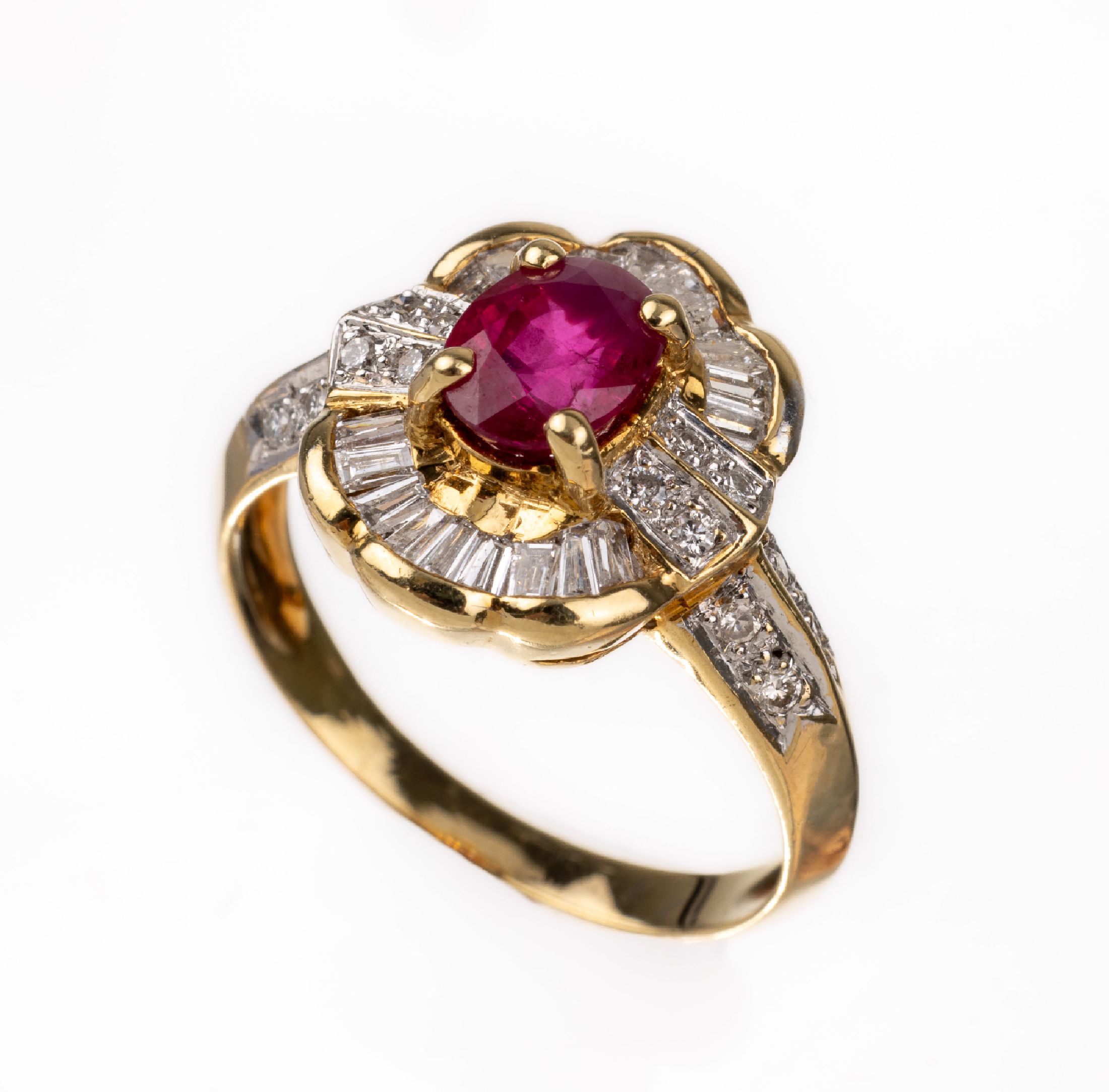 18 kt Gold Rubin-Diamant-Ring, GG 750/000, mittig erhaben gefasster ovalfacett. Rubin ca.0.80 ct, 16 Brillanten und 19 Diamanttrapeze zus. ca. 1.0 ...