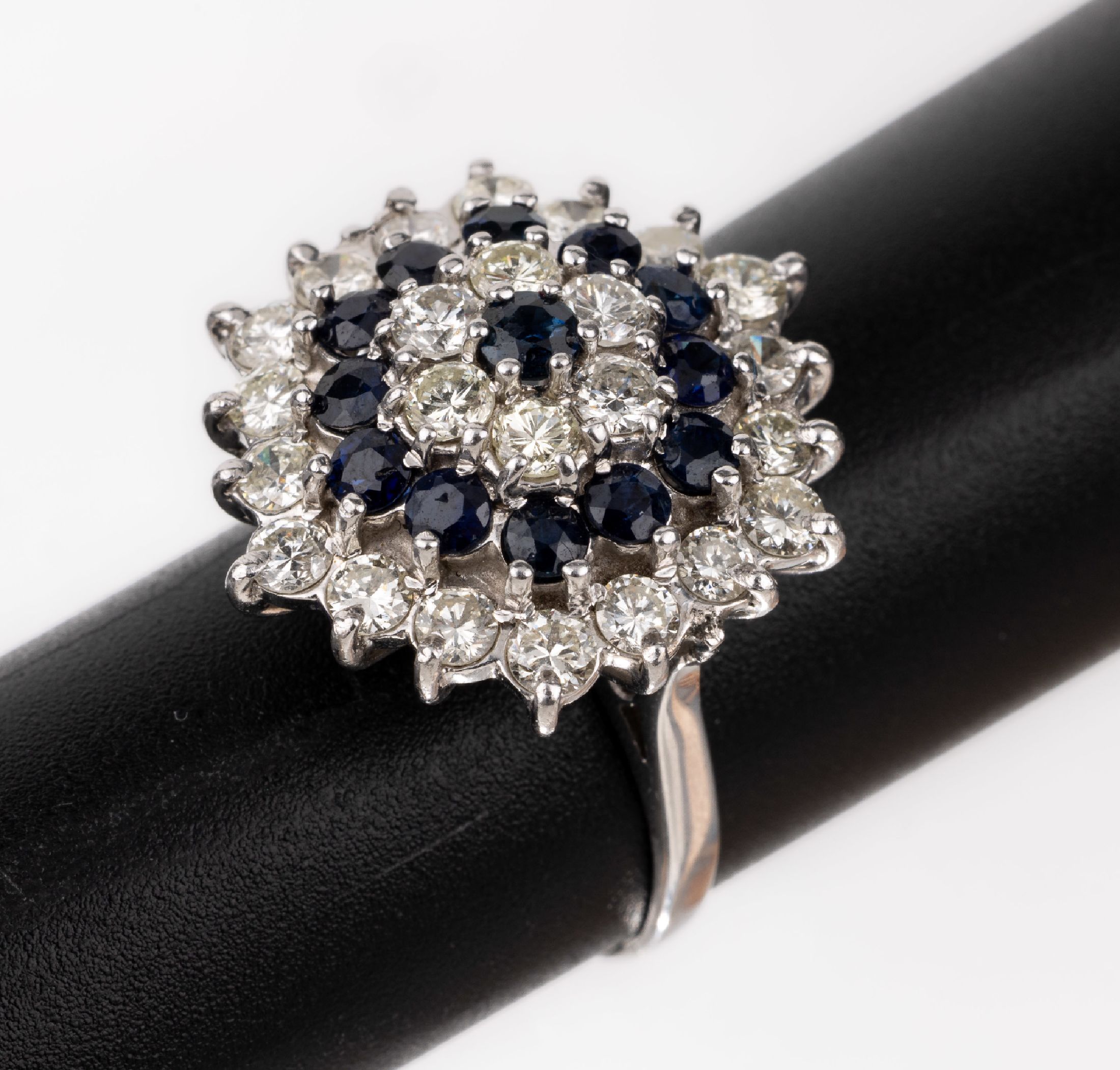 18 kt Gold Saphir-Brillant-Ring, WG 750/000, Ringkopf in mehreren Ebenen, 24 Brillanten zus. ca. 2.0 ct Weiß-l.get.Weiß/si -p, 13 rundfacett. ...