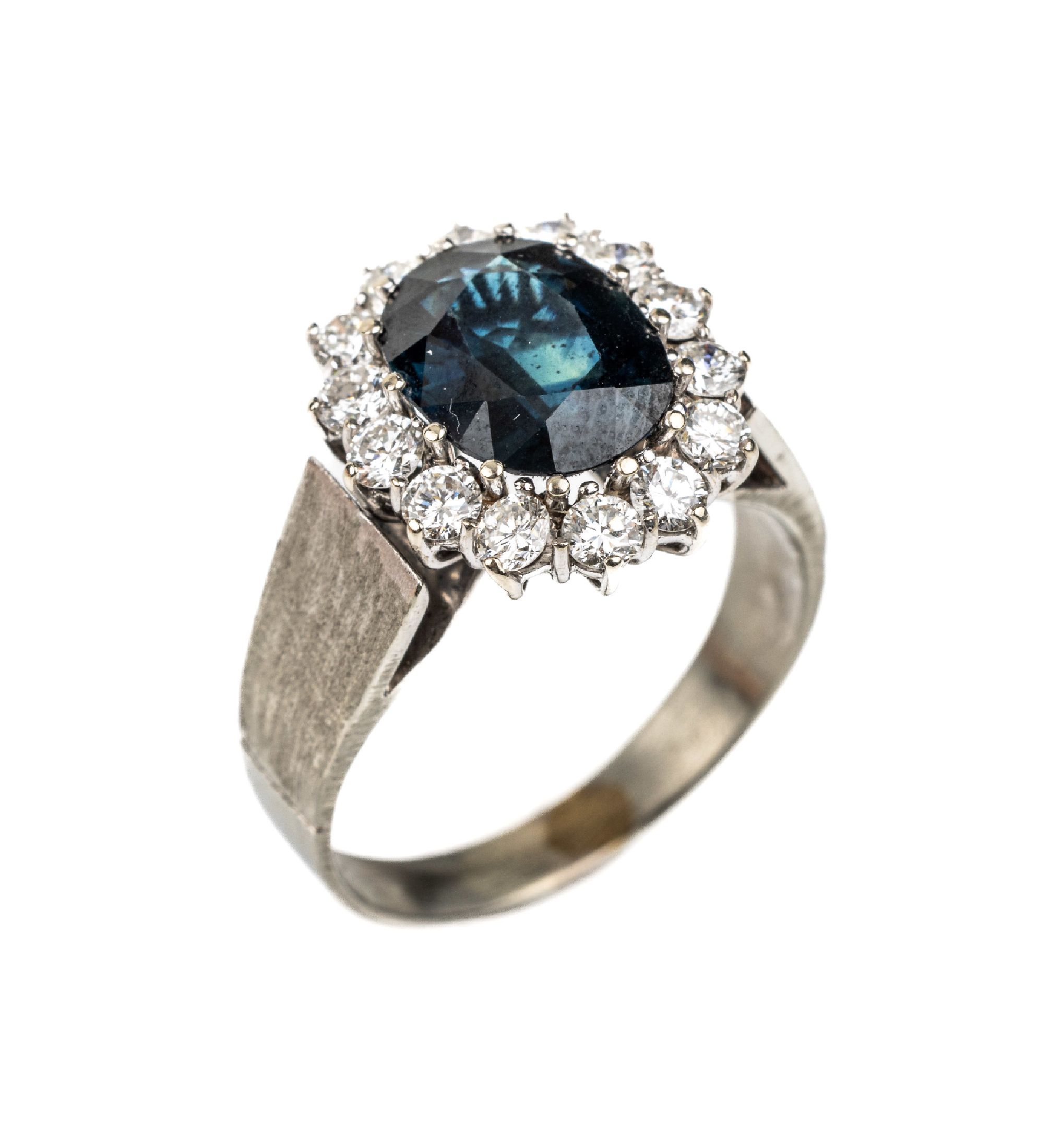14 kt Gold Saphir-Brillant-Ring, WG 585/000, mittig ovalfacett. Saphir ca. 3.34 ct, umgeben von 14 Brillanten zus. ca. 0.92 ctfeines ...