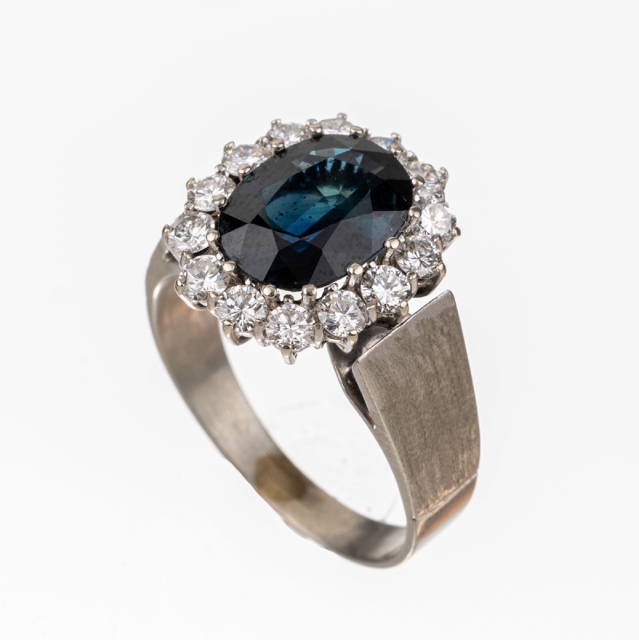 Detail a: 14 kt Gold Saphir-Brillant-Ring, WG 585/000, mittig ovalfacett. Saphir ca. 3.34 ct, umgeben von 14 Brillanten zus. ca. 0.92 ctfeines ...