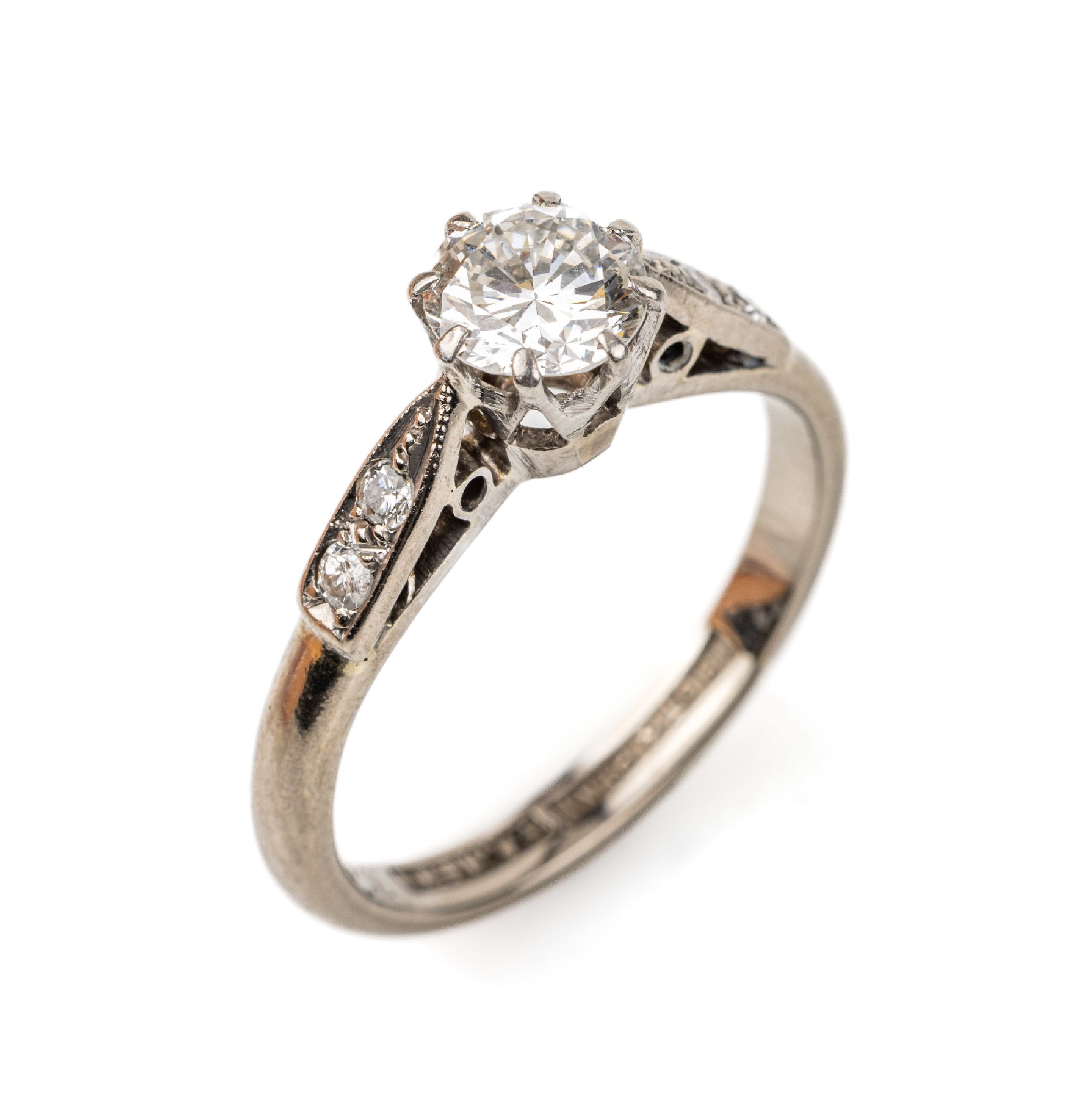 18 kt Gold Diamant-Ring, WG 750/000, mittigBrillant ca. 0.60 ct Weiß/si, Ringschultern mit 4 Brillanten zus. ca. 0.06 ct Weiß/si, RW 50, ca. 3.3 g