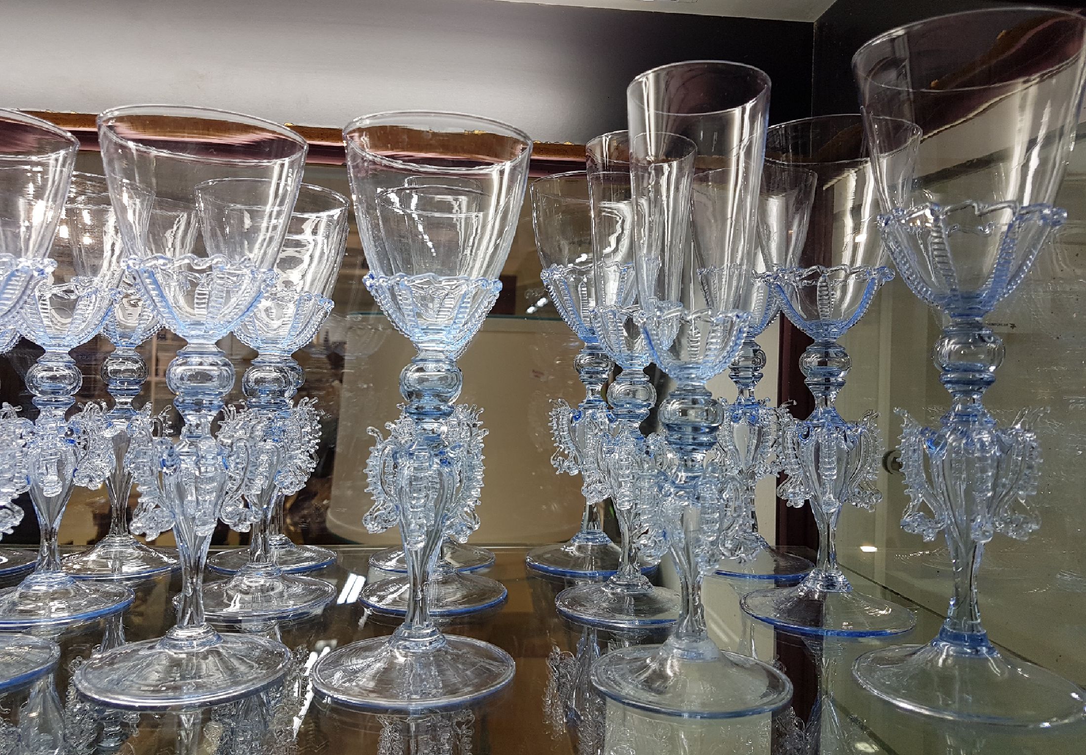 Detail a: Venezianisches Trinkglasservice, 20. Jh., leicht bläuliches Glas, mundgeblasen, reich verziert, 4 große Kelchgläser H. ca. 24 cm, 8 Weingläser H. ...