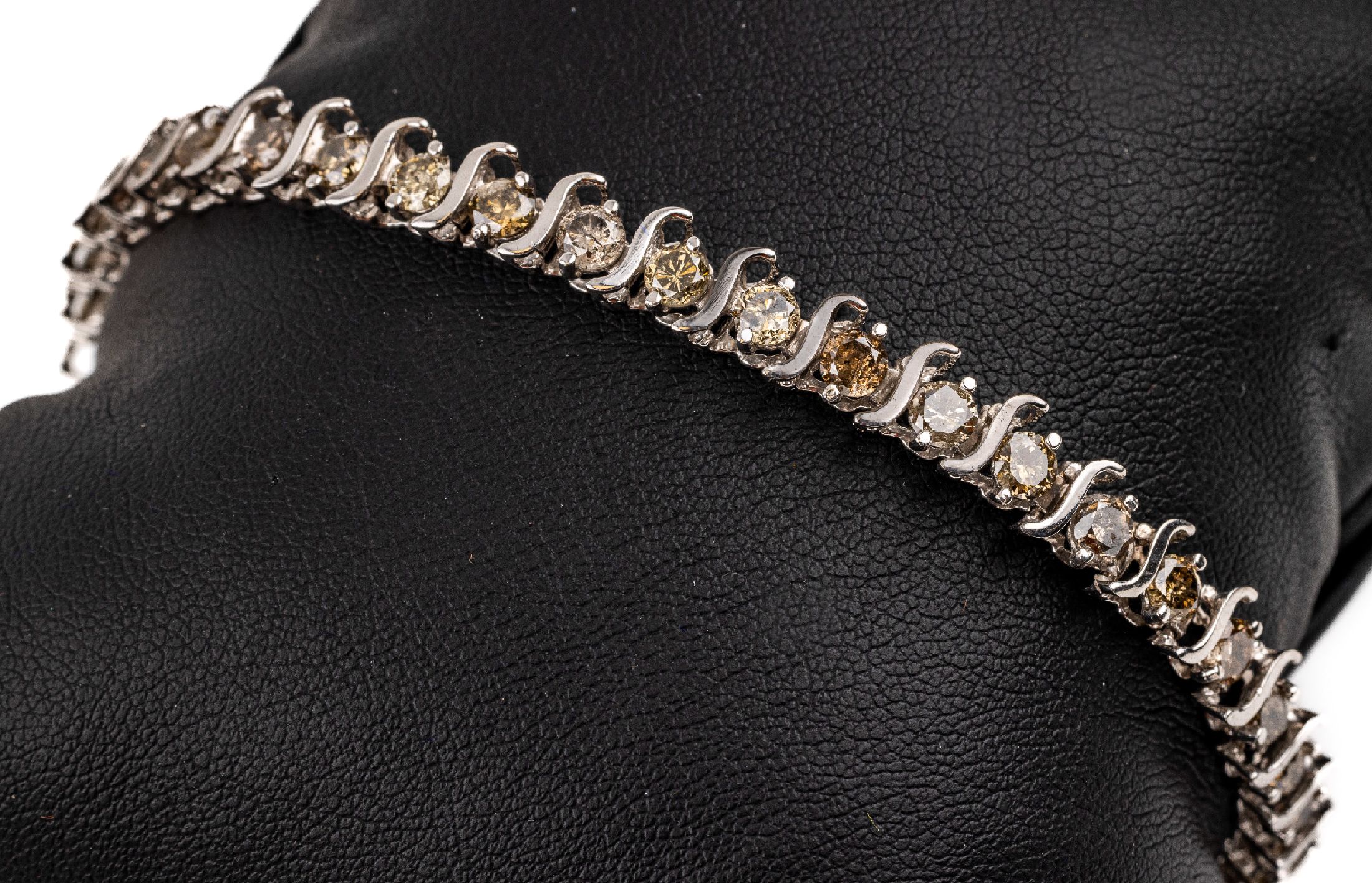 10 kt Gold Brillant-Armband, WG 416/000, 35Brillanten zus. ca. 5.25 ct Braun/p 1, S-förmige Zwischenglieder, L. ca. 18 cm, Kastenschloss mit ...