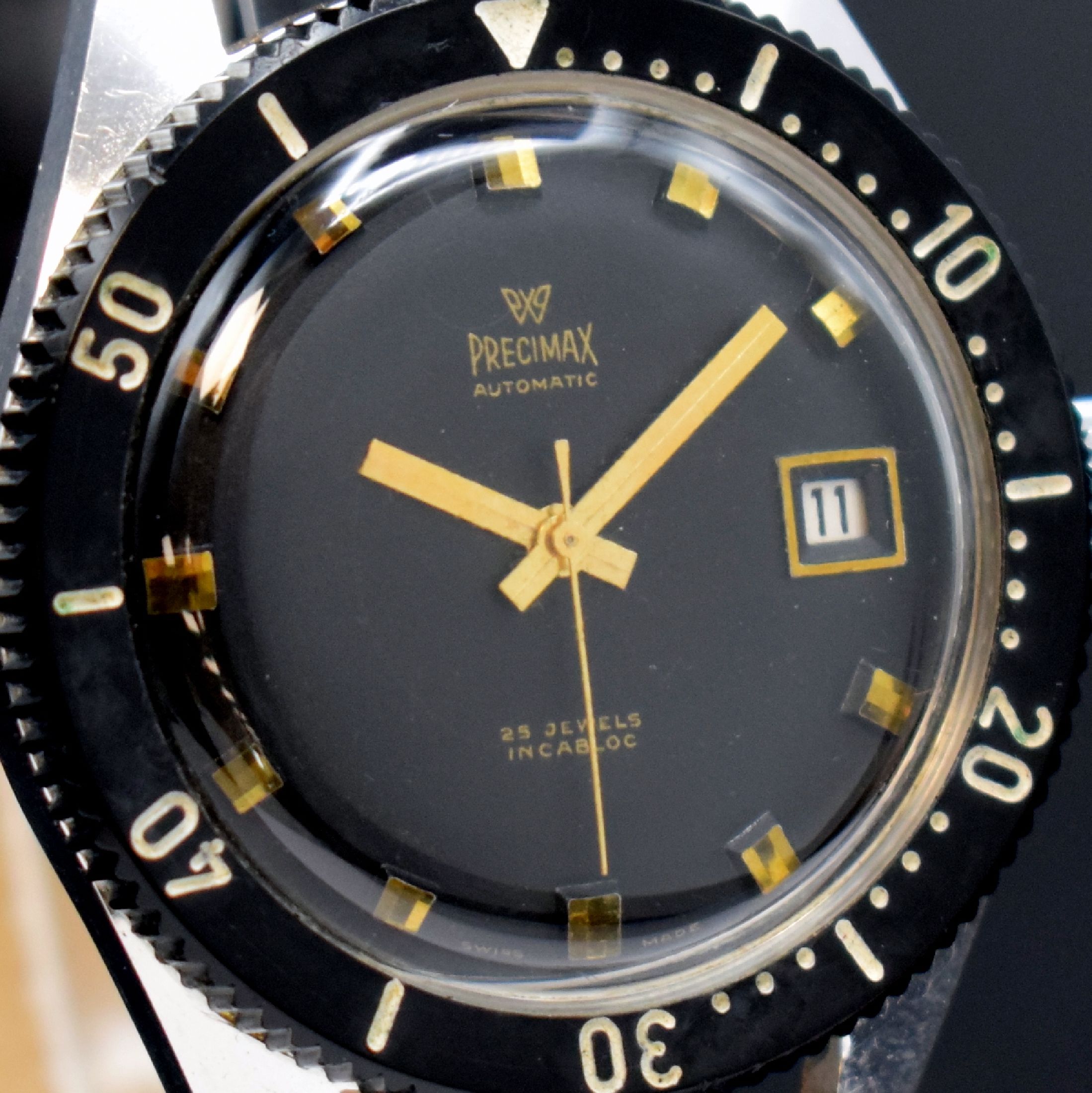 Detail b: PRECIMAX gut erhaltene Herrenarmbanduhr 37,5 mm, Schweiz um 1960, Automatik, 2-teil. verchr. Gehäuse, Boden geschr., schwarze Lünette m. 60er ...