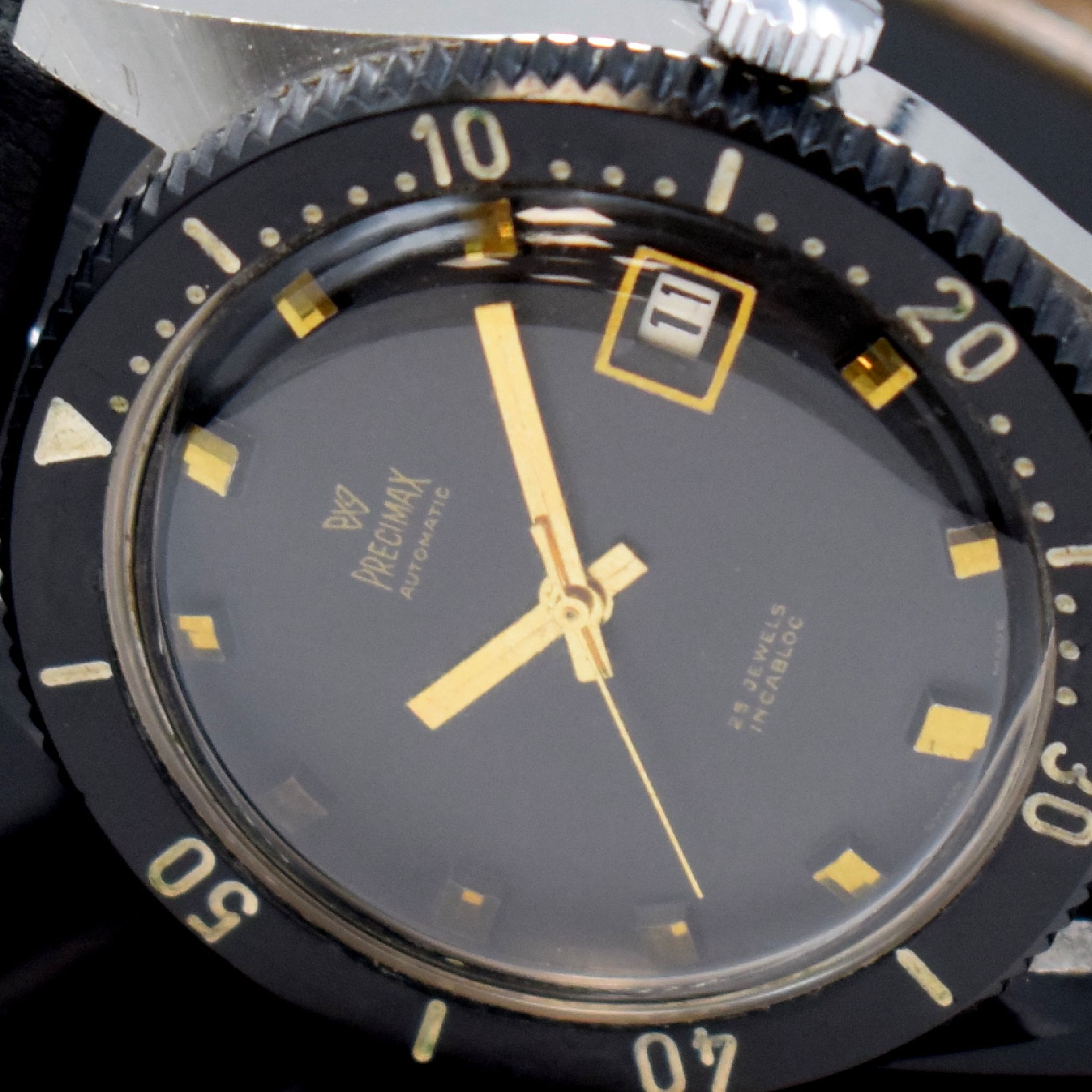 Detail e: PRECIMAX gut erhaltene Herrenarmbanduhr 37,5 mm, Schweiz um 1960, Automatik, 2-teil. verchr. Gehäuse, Boden geschr., schwarze Lünette m. 60er ...