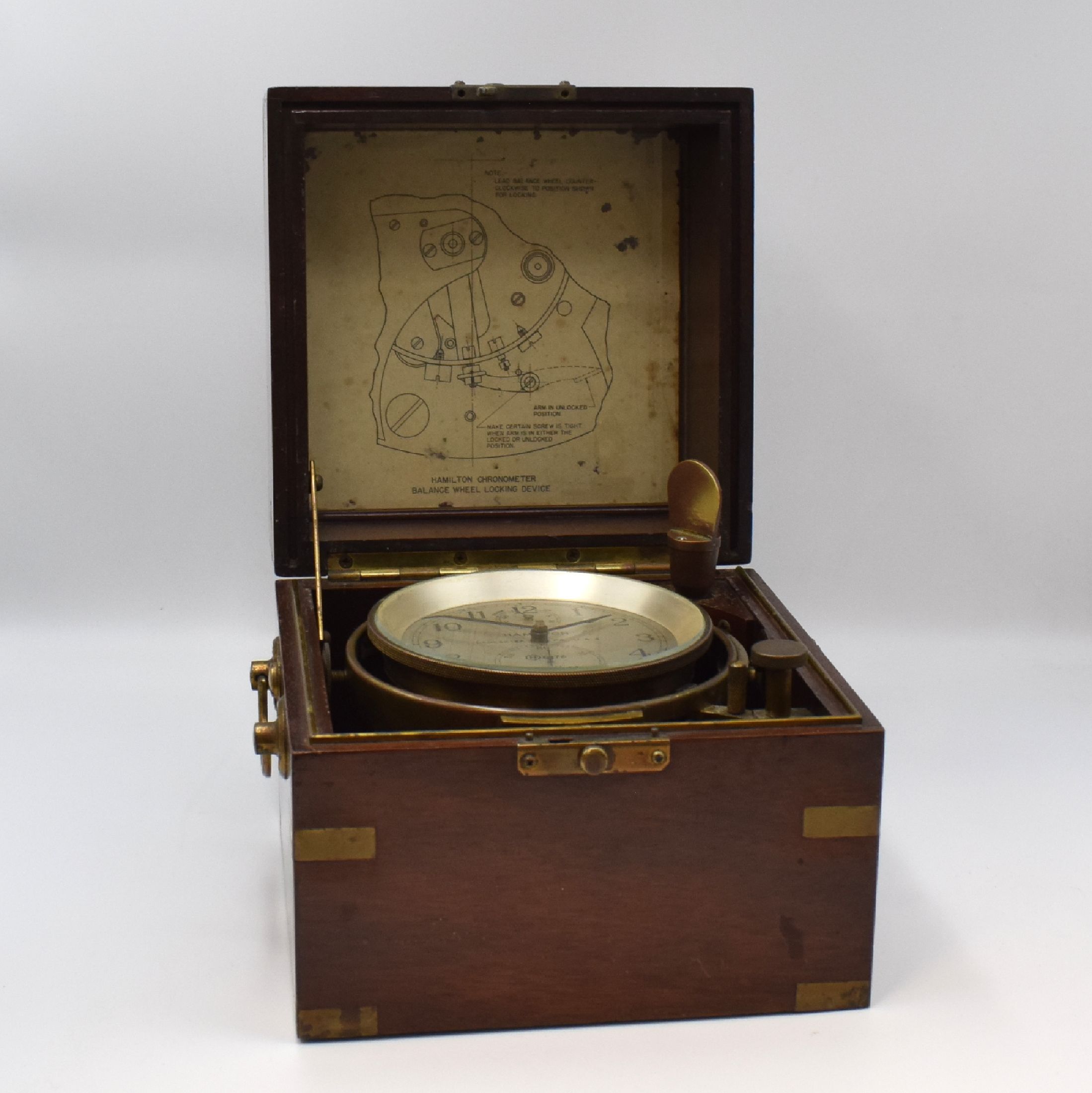 Detail d: HAMILTON Modell 21 Marinechronometer mit Transportkiste, USA um 1941, zaponiertes, kardanisch aufgehängtes Messinggeh. pat., Lünette verschr., ...