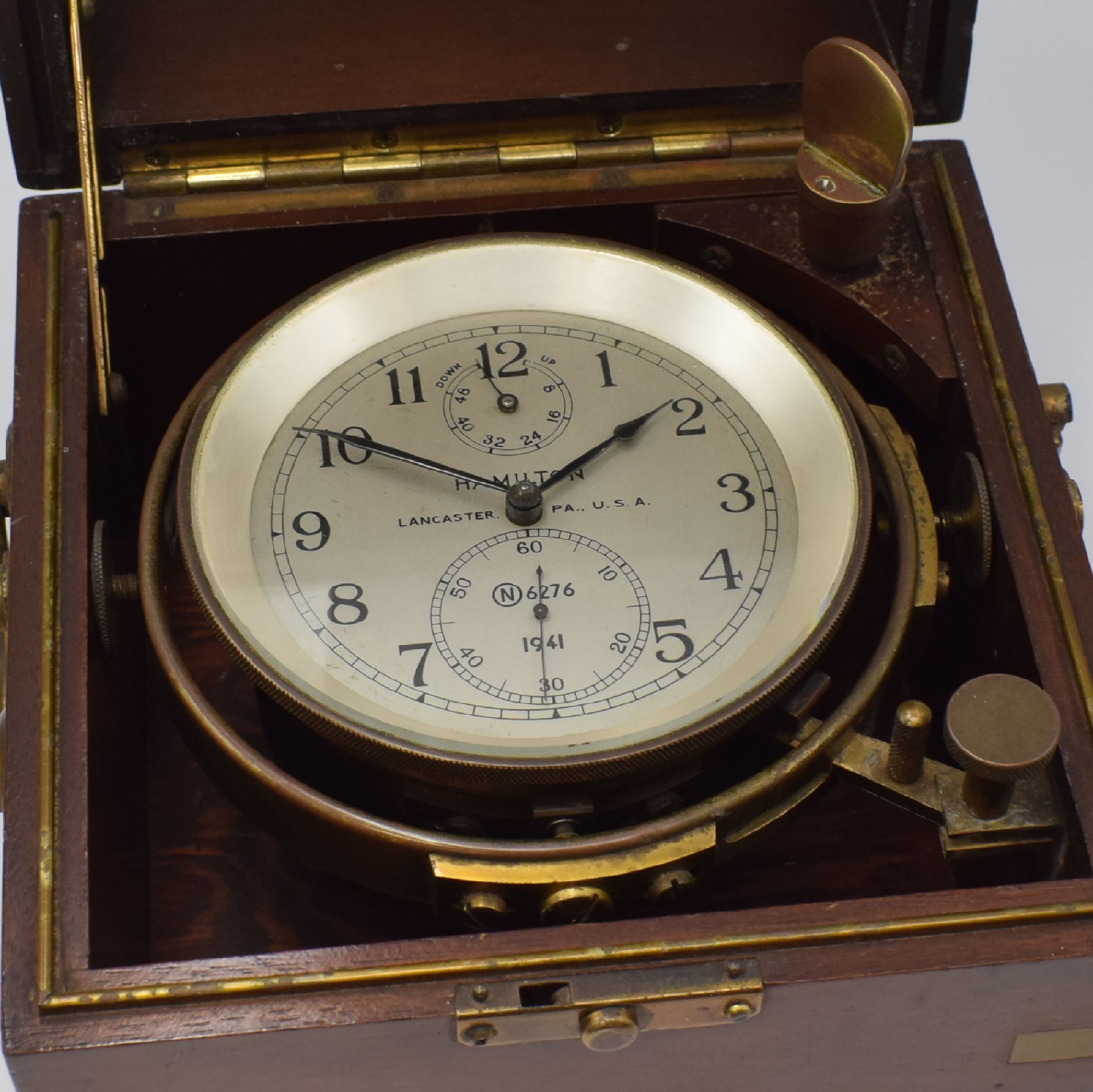 Detail e: HAMILTON Modell 21 Marinechronometer mit Transportkiste, USA um 1941, zaponiertes, kardanisch aufgehängtes Messinggeh. pat., Lünette verschr., ...