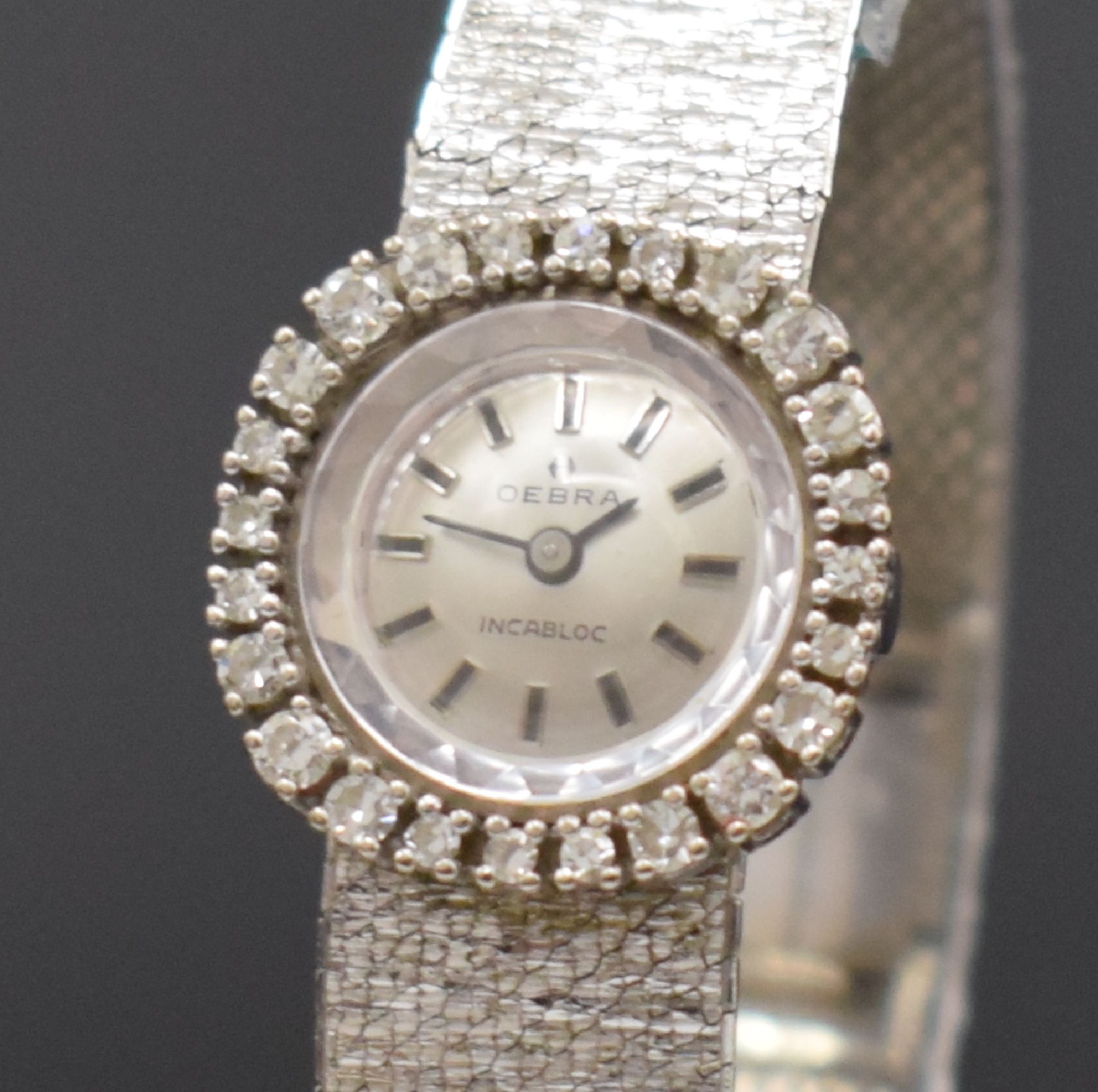 Detail a: OEBRA Damenarmbanduhr in WG 585/000, Schweiz um 1970, Handaufzug, 2-teil. Gehäuse, Boden aufgedr., Milanaiseband, Lünette m. Diamanten bes., Kal. ...