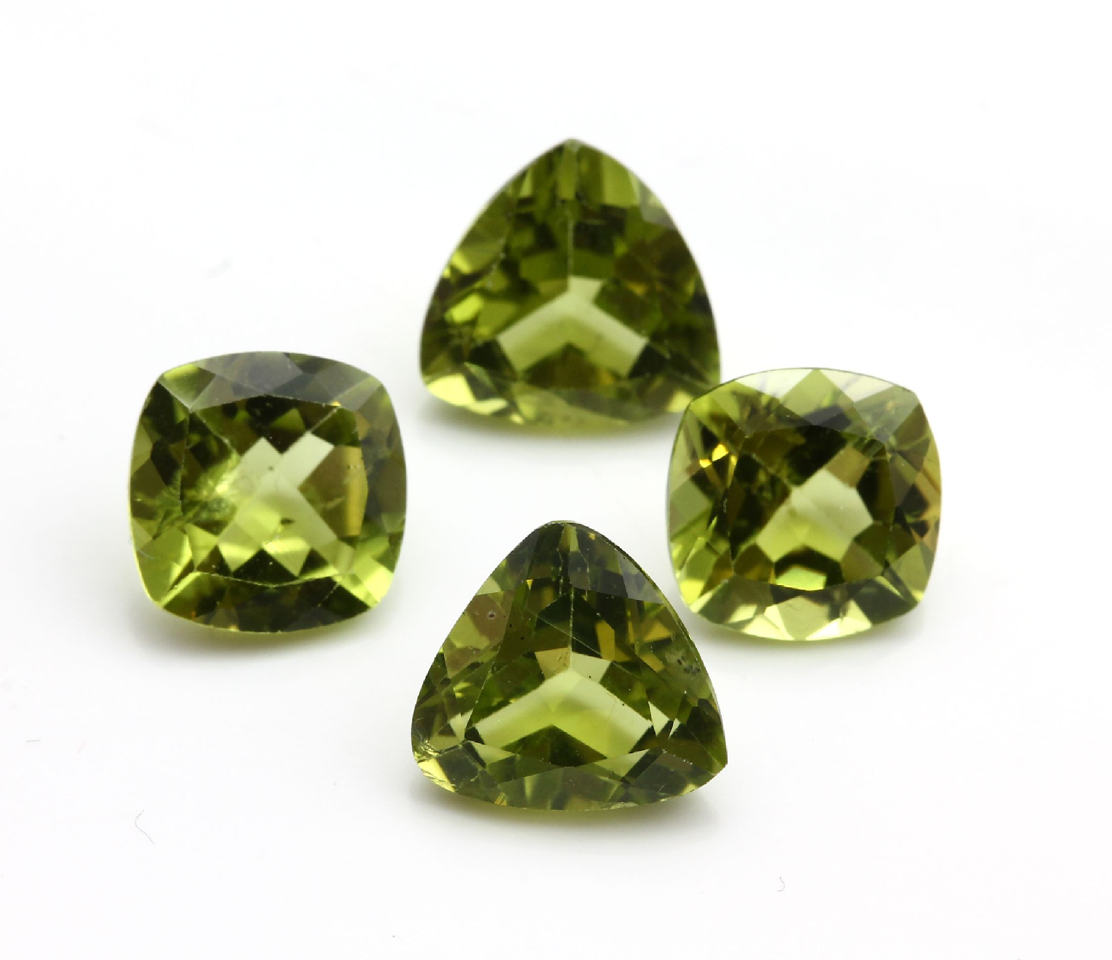 Konvolut 12 Peridots zus. ca. 29.50 ct: 4 x im facett. Triangelschliff zus. ca. 10.20 ct; 4 x im Kissenschliff zus. ca. 8.90 ct; 4 x im facett. ...