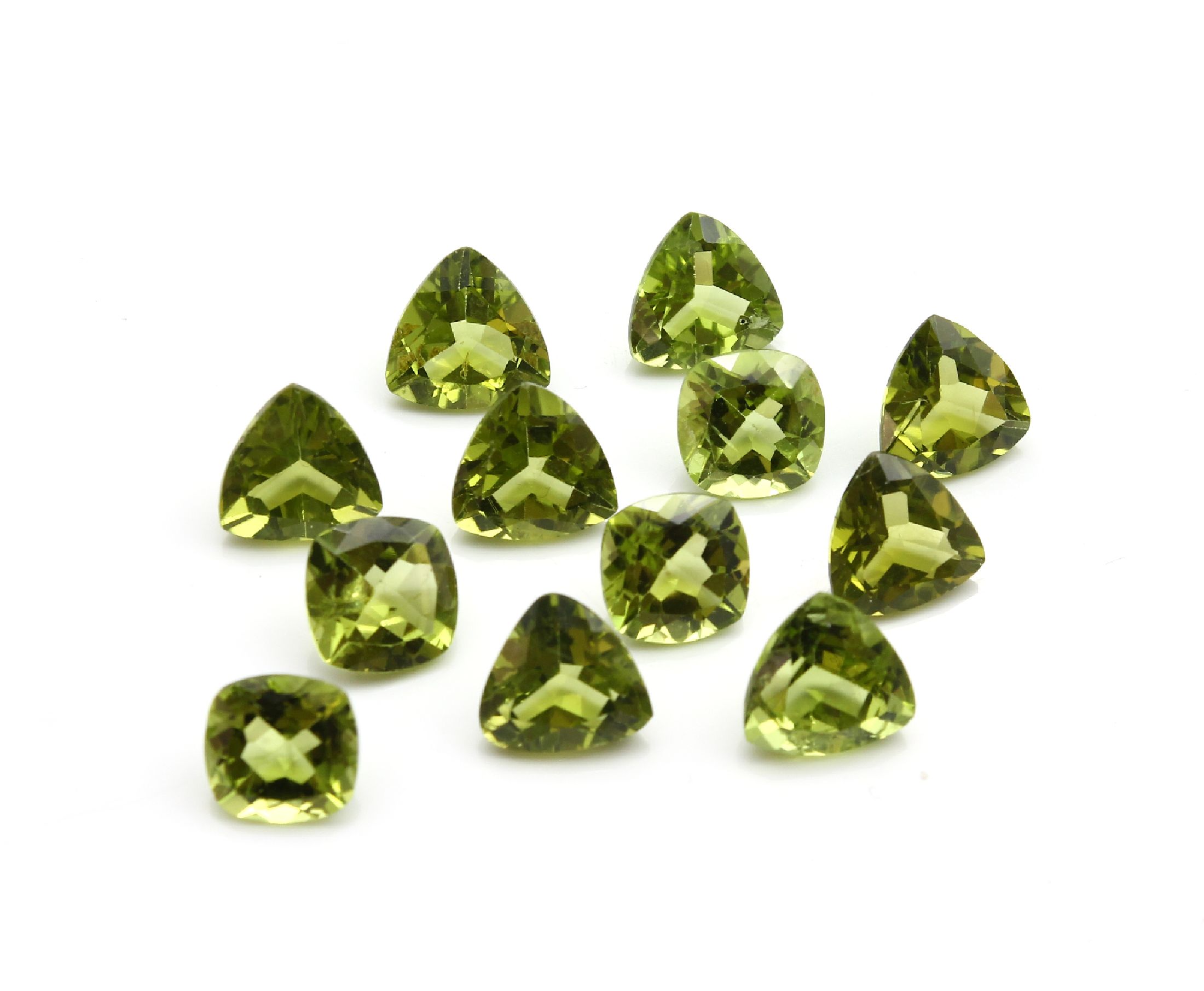 Detail a: Konvolut 12 Peridots zus. ca. 29.50 ct: 4 x im facett. Triangelschliff zus. ca. 10.20 ct; 4 x im Kissenschliff zus. ca. 8.90 ct; 4 x im facett. ...