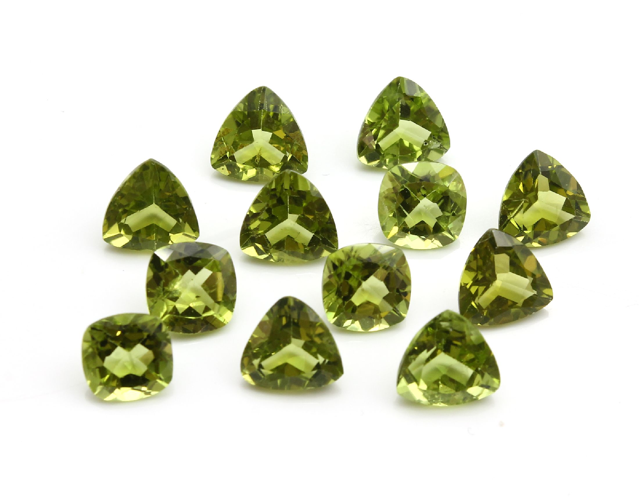 Detail b: Konvolut 12 Peridots zus. ca. 29.50 ct: 4 x im facett. Triangelschliff zus. ca. 10.20 ct; 4 x im Kissenschliff zus. ca. 8.90 ct; 4 x im facett. ...