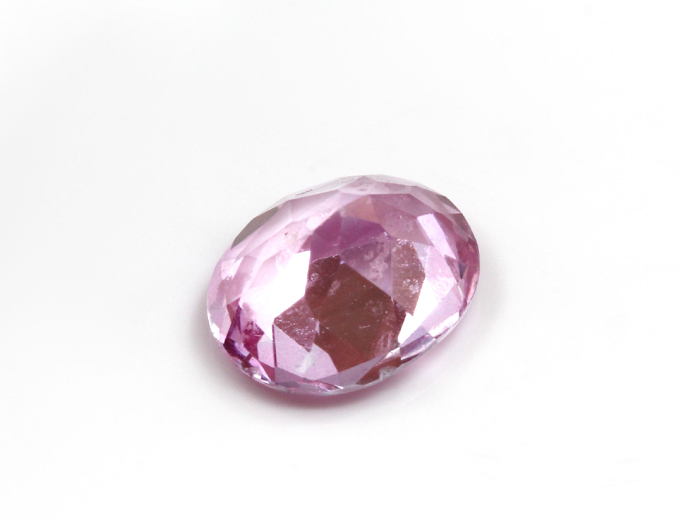 Detail a: Loser pinkfarb. Topas (beh.), ca. 4.29 ct, ovalfacett.