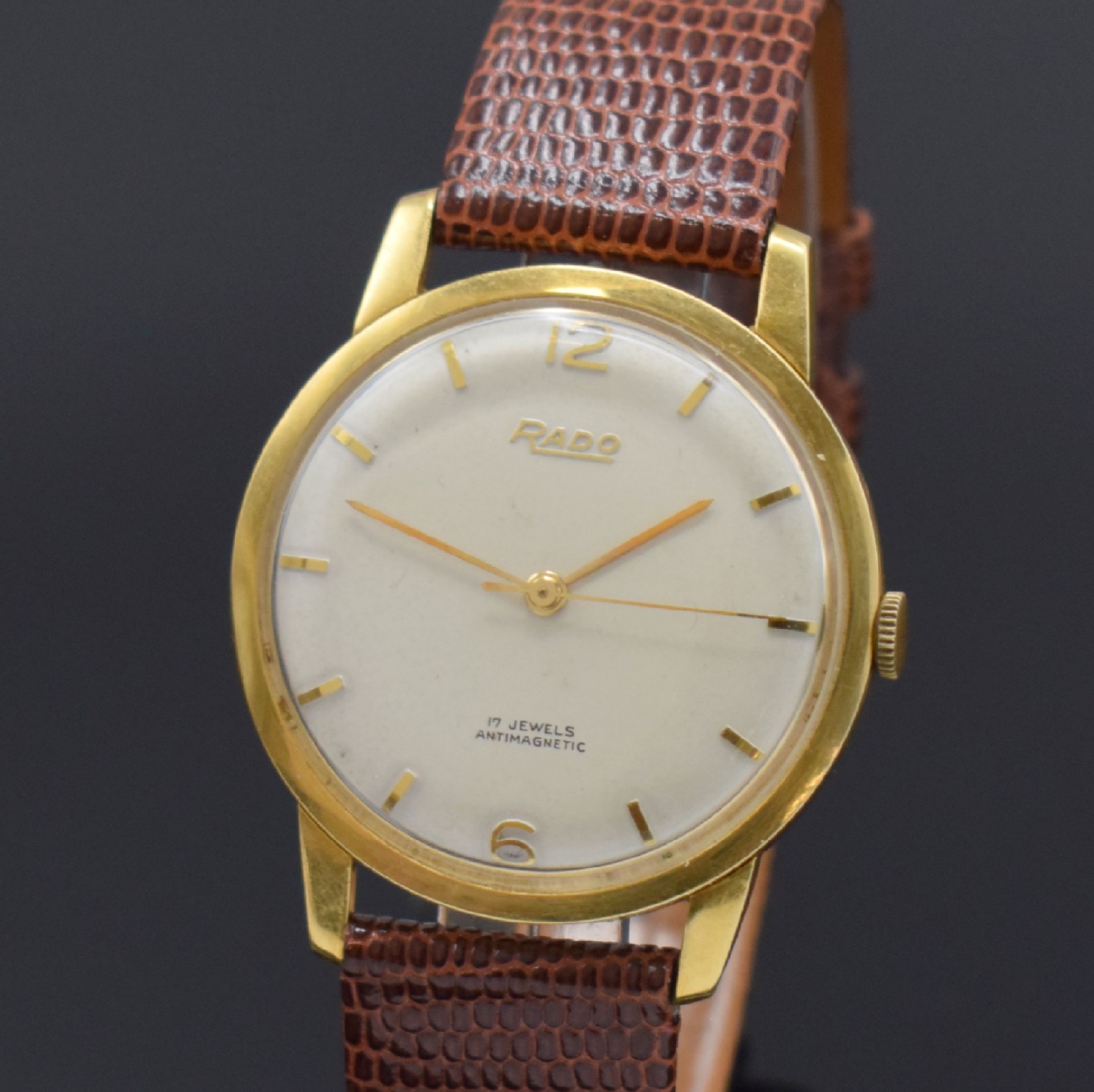 Detail a: RADO Herrenarmbanduhr in GG 750/000, Schweiz um 1960, Handaufzug, Glasrand aufgedr., Boden/Geh. dell., silb. Zifferbl. m. gold. Std.-Ind. l. fl., ...
