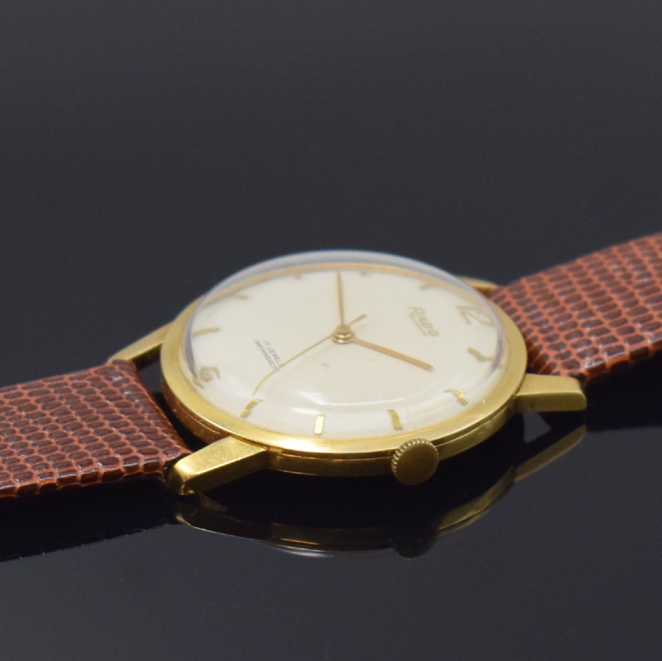 Detail b: RADO Herrenarmbanduhr in GG 750/000, Schweiz um 1960, Handaufzug, Glasrand aufgedr., Boden/Geh. dell., silb. Zifferbl. m. gold. Std.-Ind. l. fl., ...