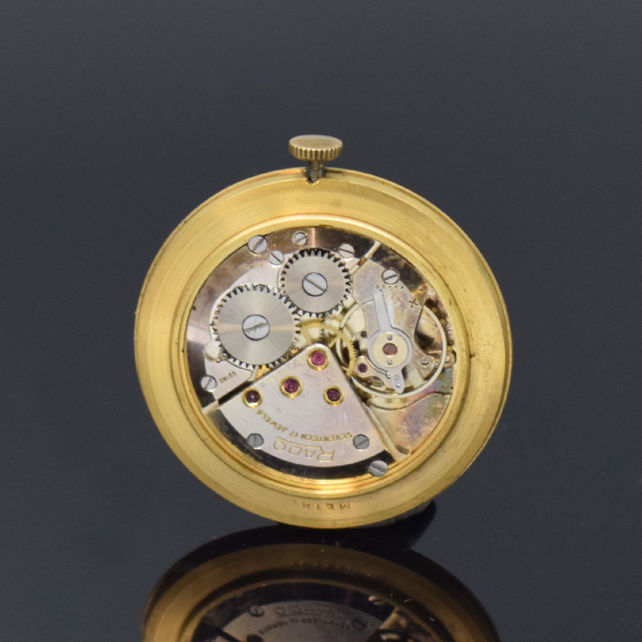Detail d: RADO Herrenarmbanduhr in GG 750/000, Schweiz um 1960, Handaufzug, Glasrand aufgedr., Boden/Geh. dell., silb. Zifferbl. m. gold. Std.-Ind. l. fl., ...